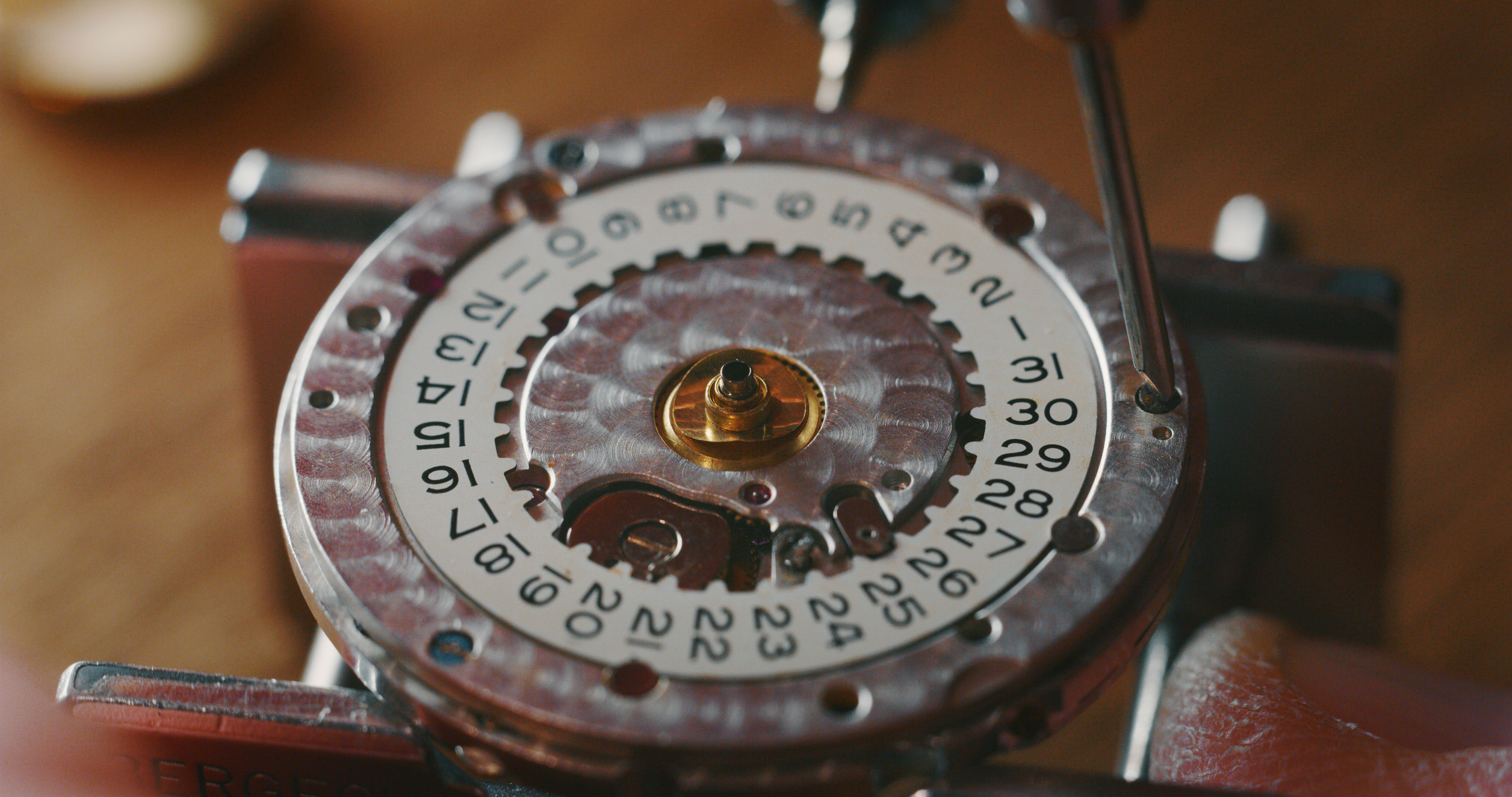 Portrait close up of a professional watchmaker repairer working on a vintage mechanism clock in a workshop.