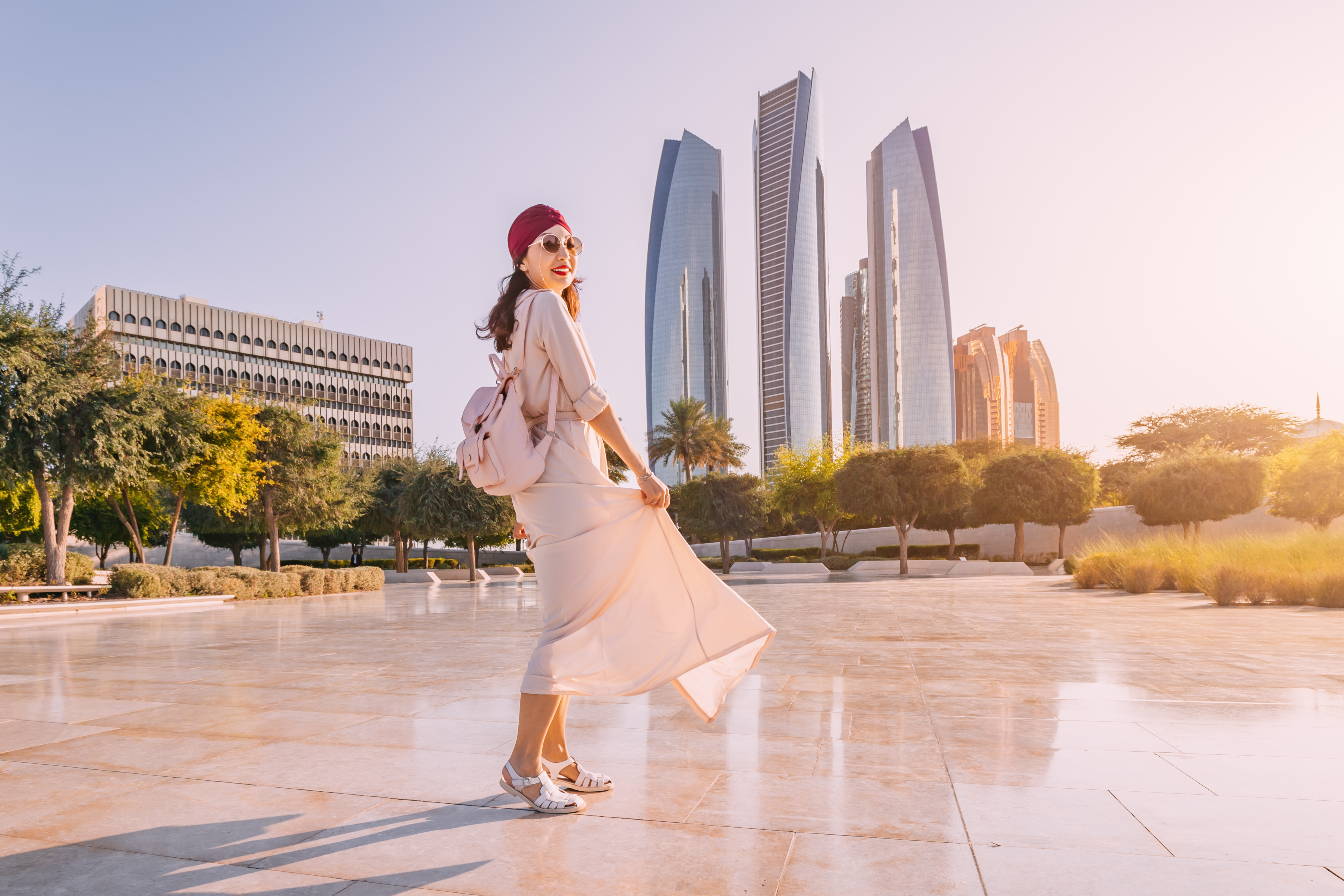 Experience the fusion of modernity and tradition as an Indian woman walks against the backdrop of Abu Dhabi's iconic skyscrapers.