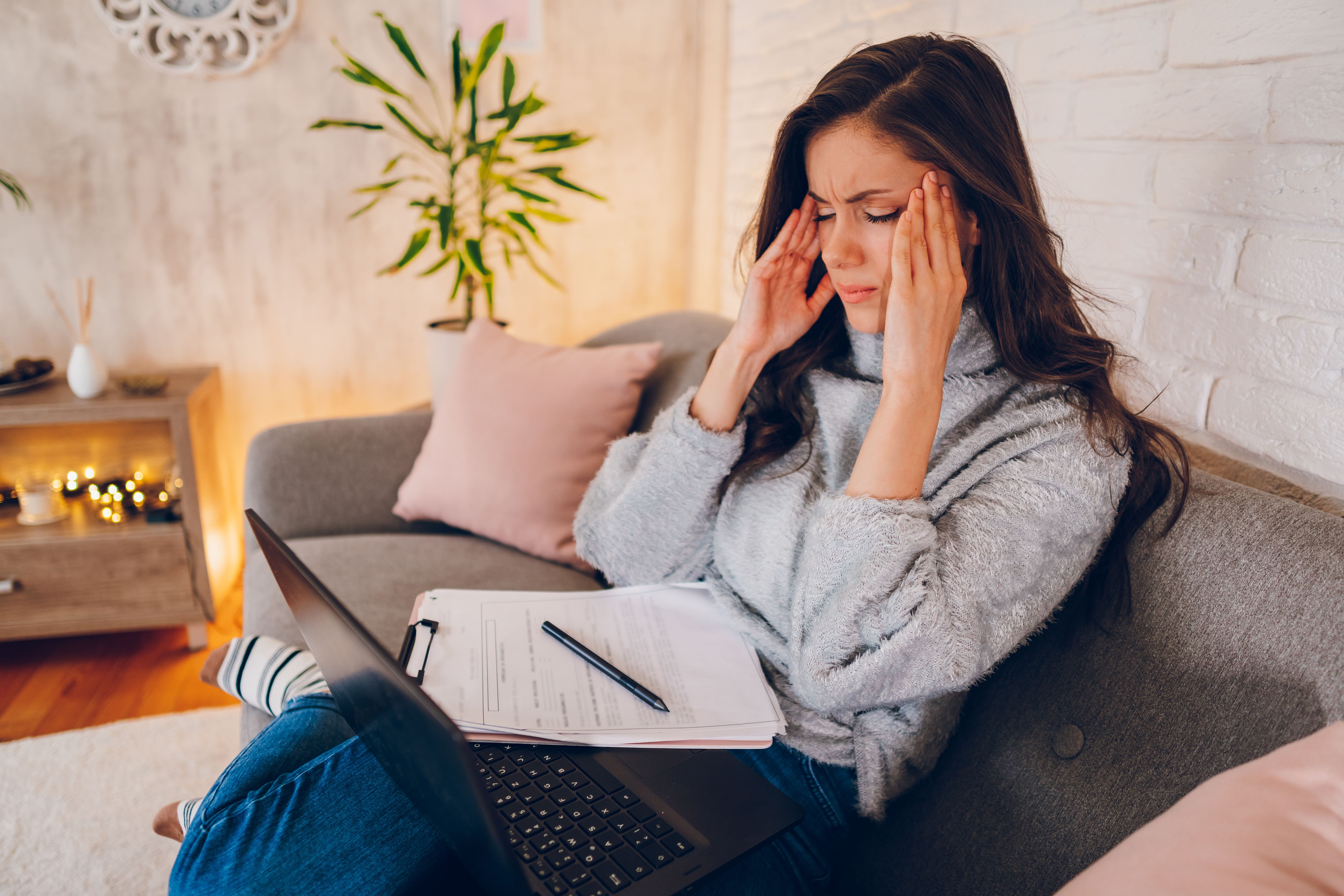 A exhausted frustrated young business woman working at home