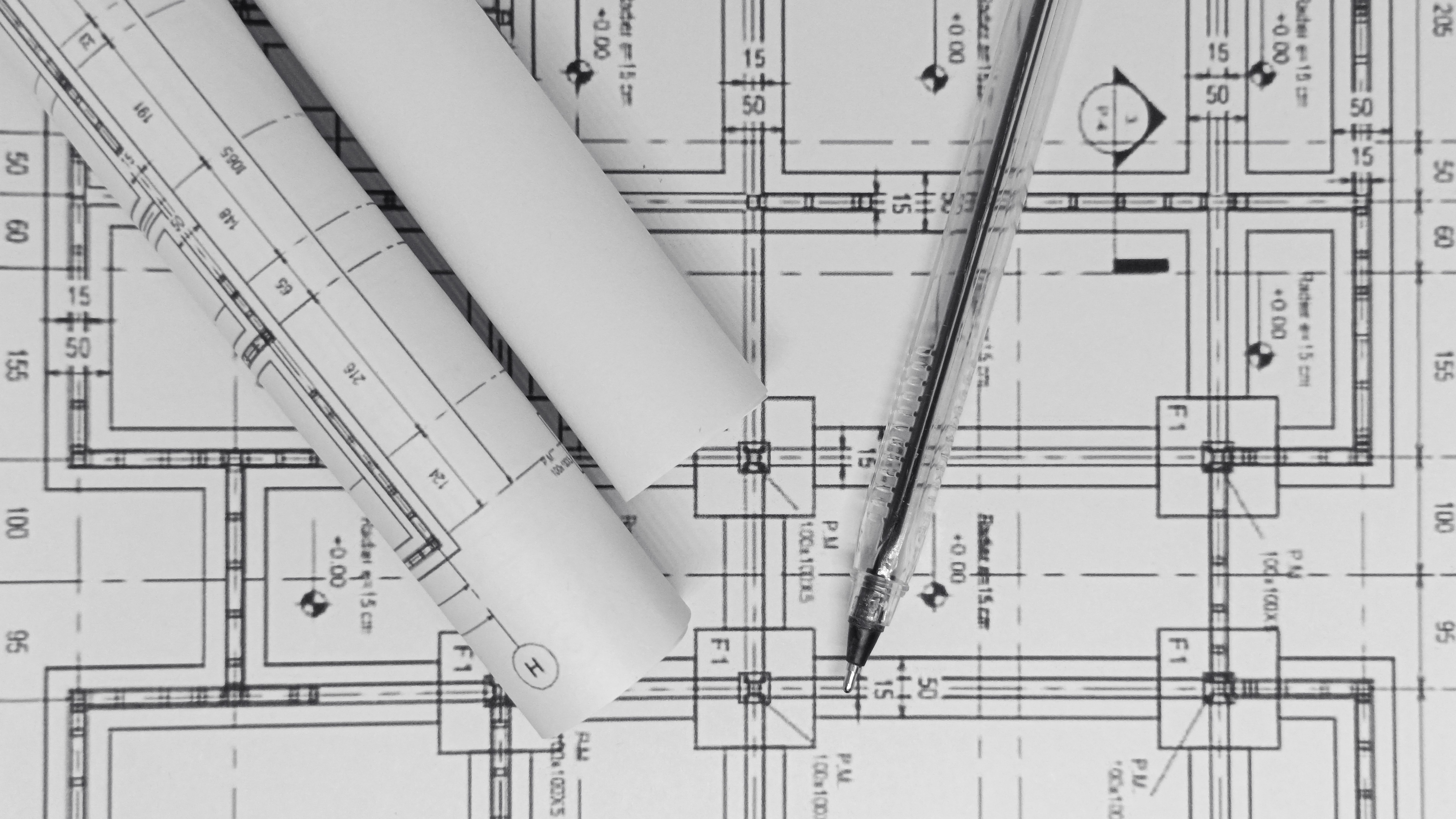 Architectural blueprints with rolled plans and ruler