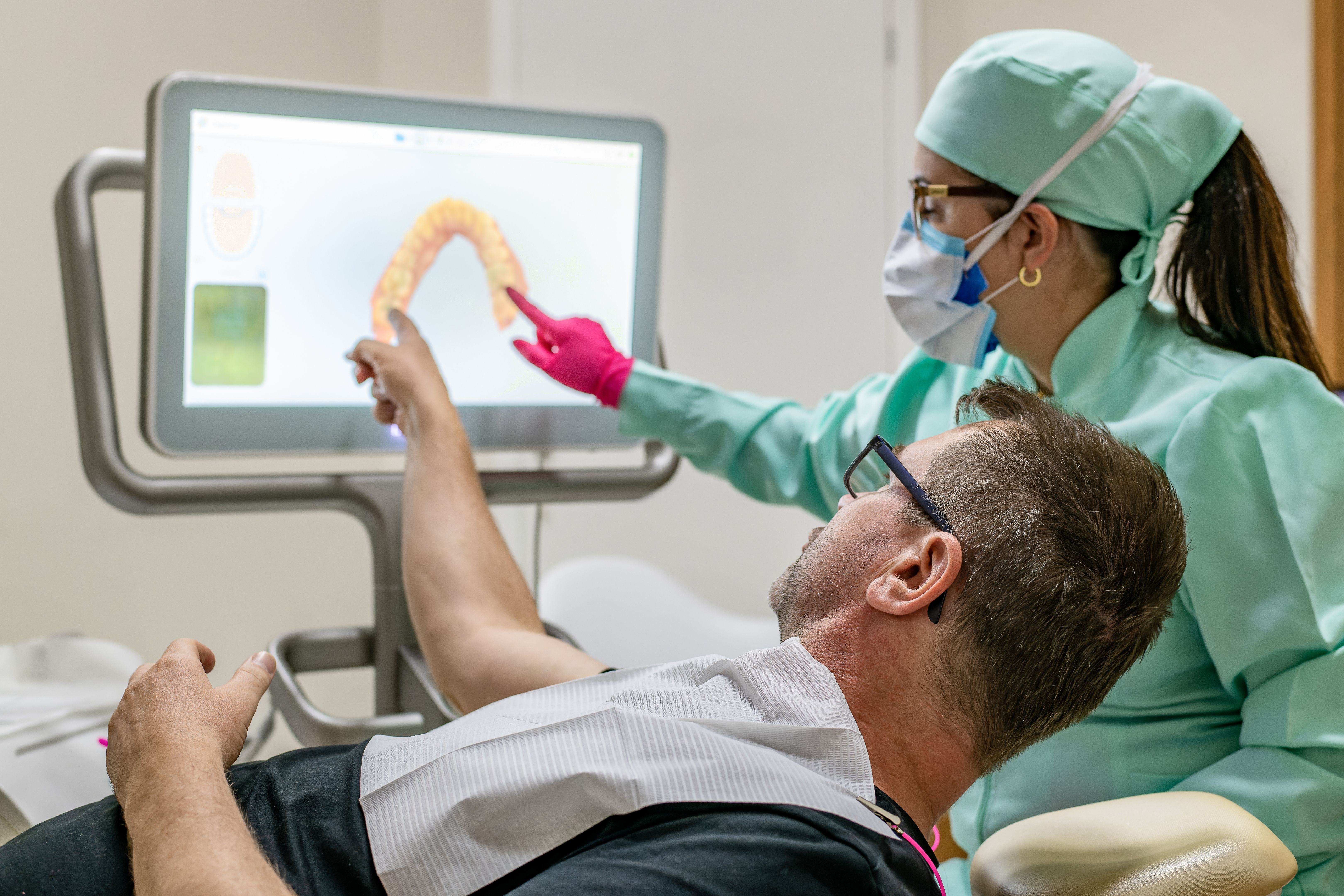 Patient and dentist discussing the need for intervention in the patient's teeth with the 3D technology aid