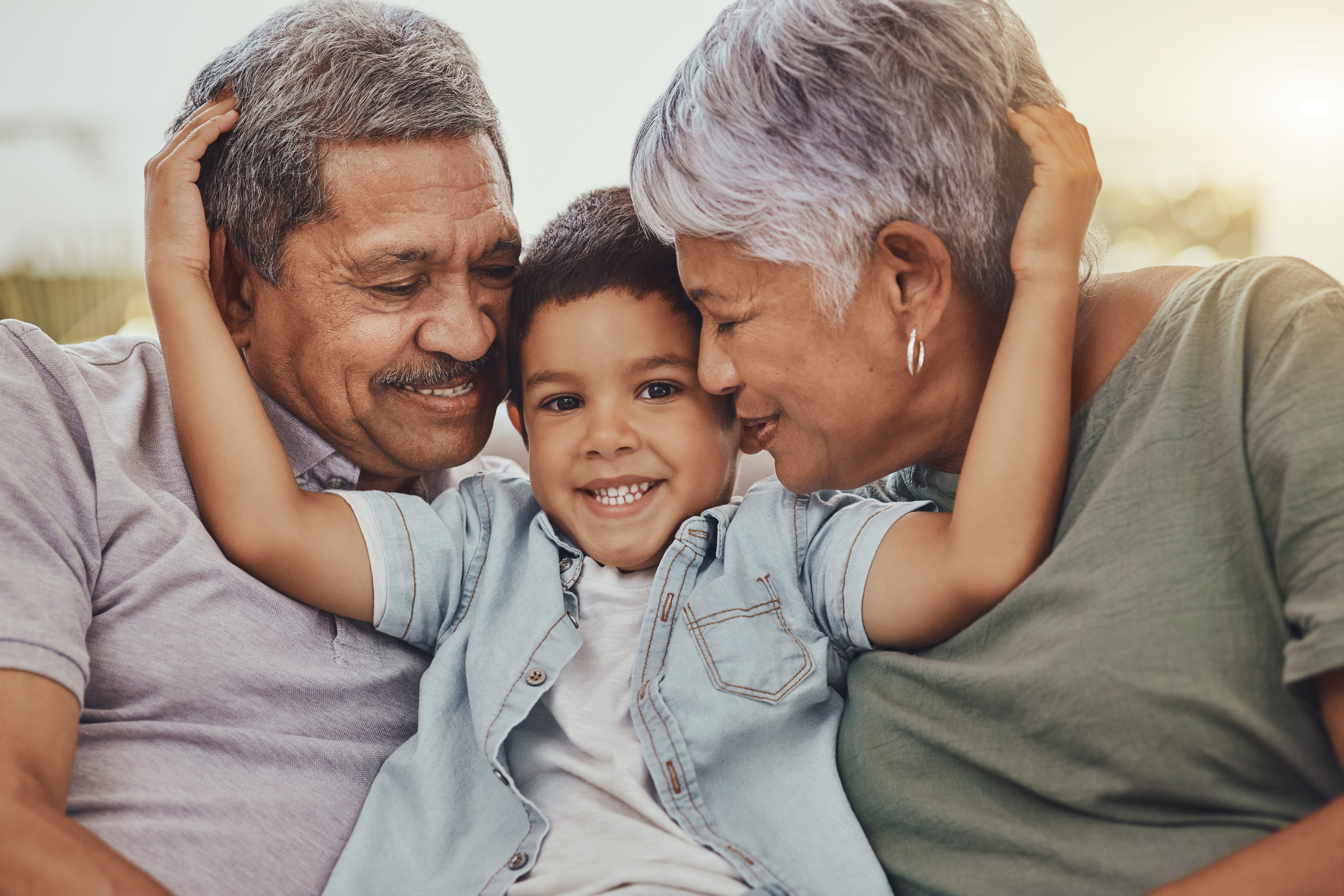 Family, portrait and child with grandparents in a living room, hug and happy, love and sweet while bonding in their home. Embrace, grandchild and grandmother with grandfather in a lounge hugging Family, portrait and child with grandparents in a living room, hug and happy, love and sweet while bonding in their home. Embrace, grandchild and grandmother with grandfather in a lounge hugging