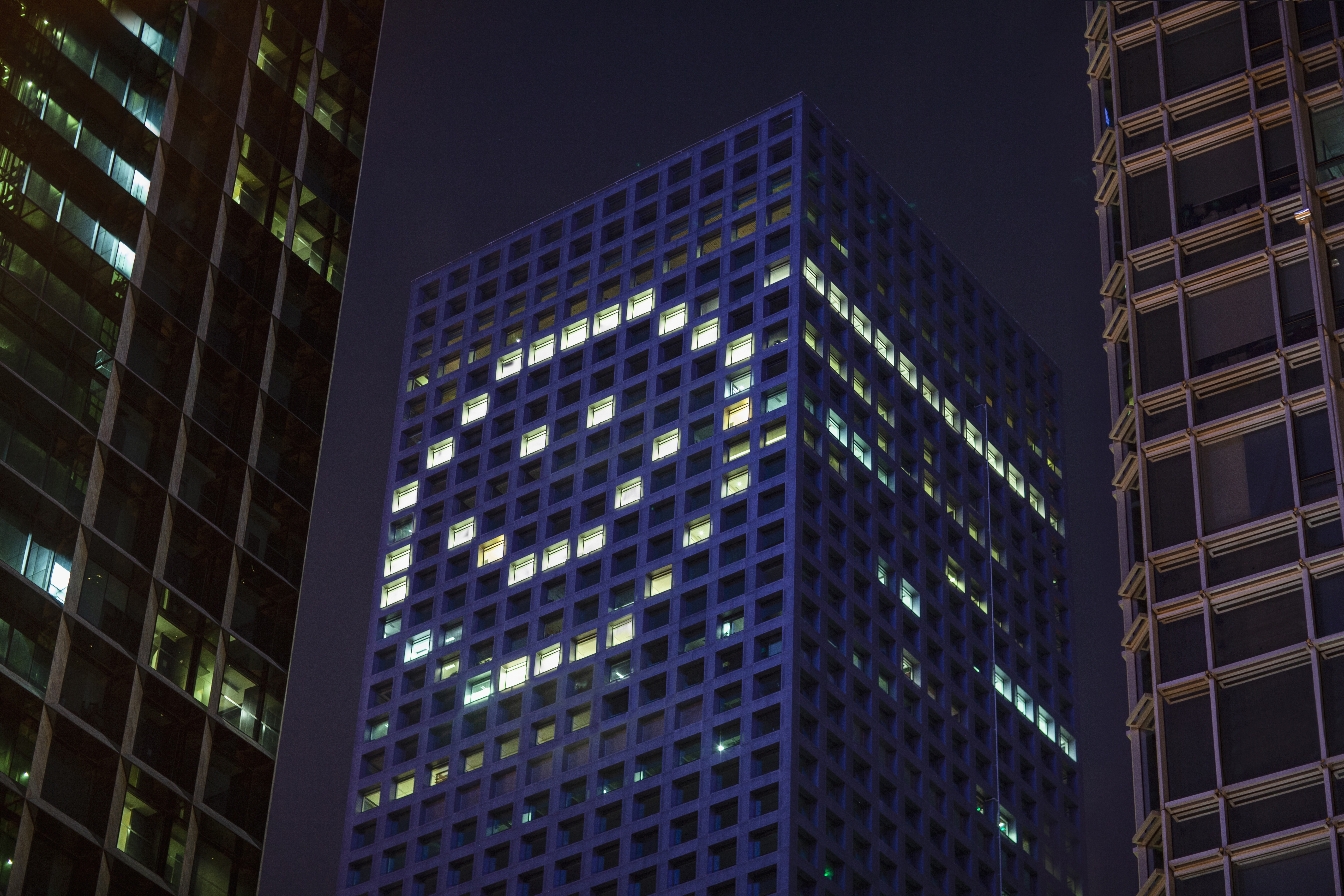 Happy face shape in lights in downtown district office business buildings at night
