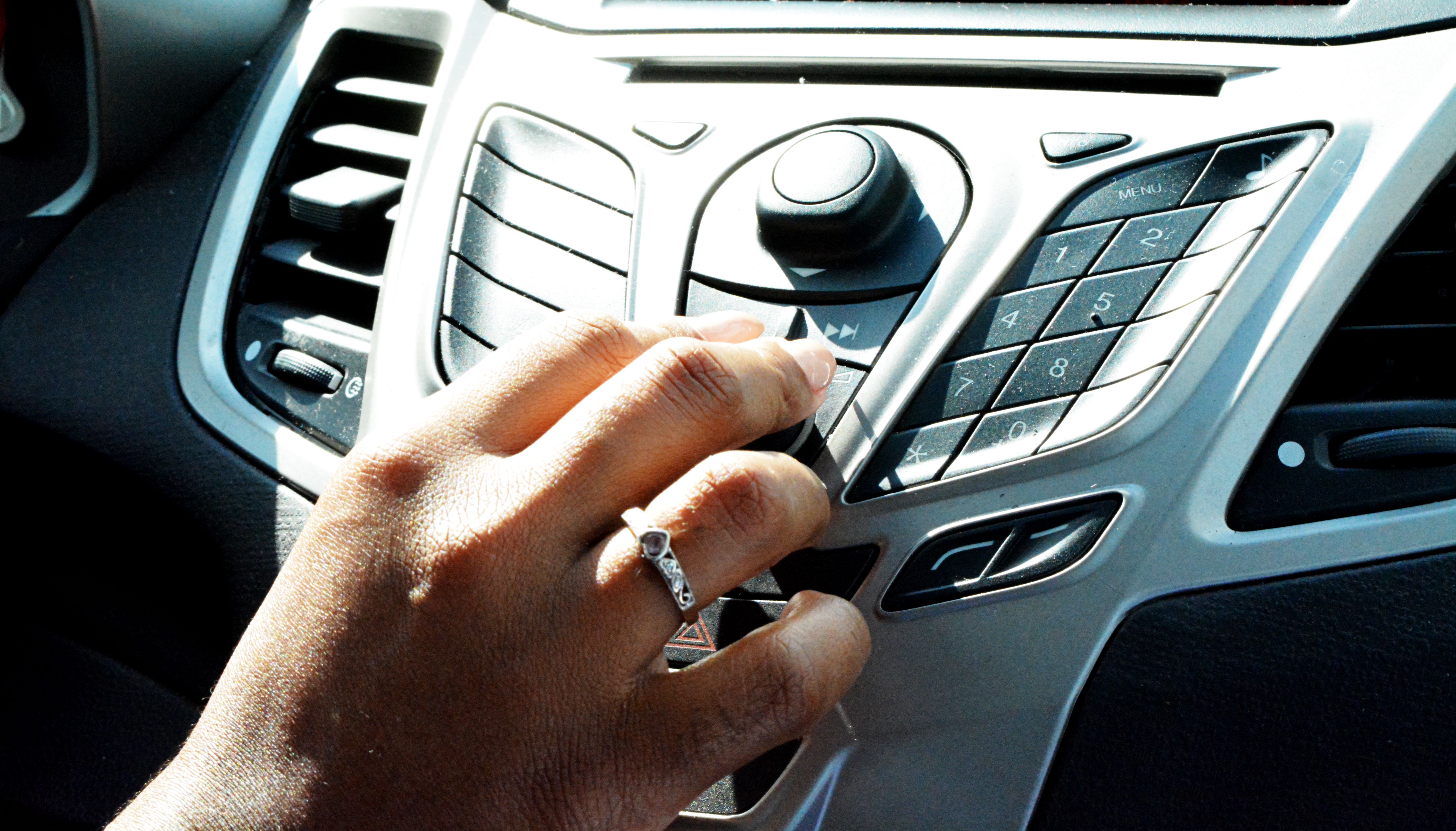 Hands on a steering wheel as the light shines in the car