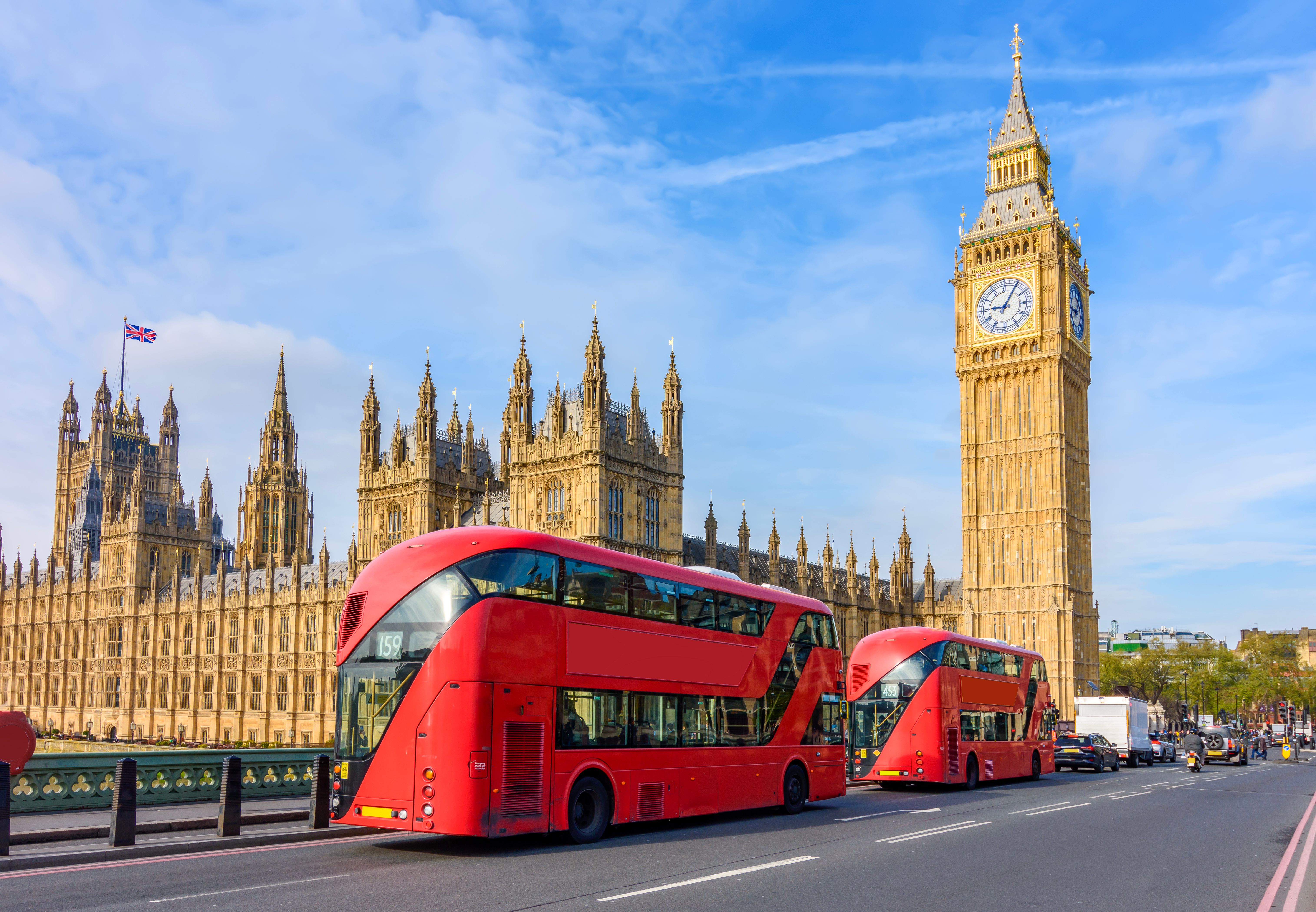 Houses of Parliament with Big Ben and double-decker buses on Westminster bridge, London, UK