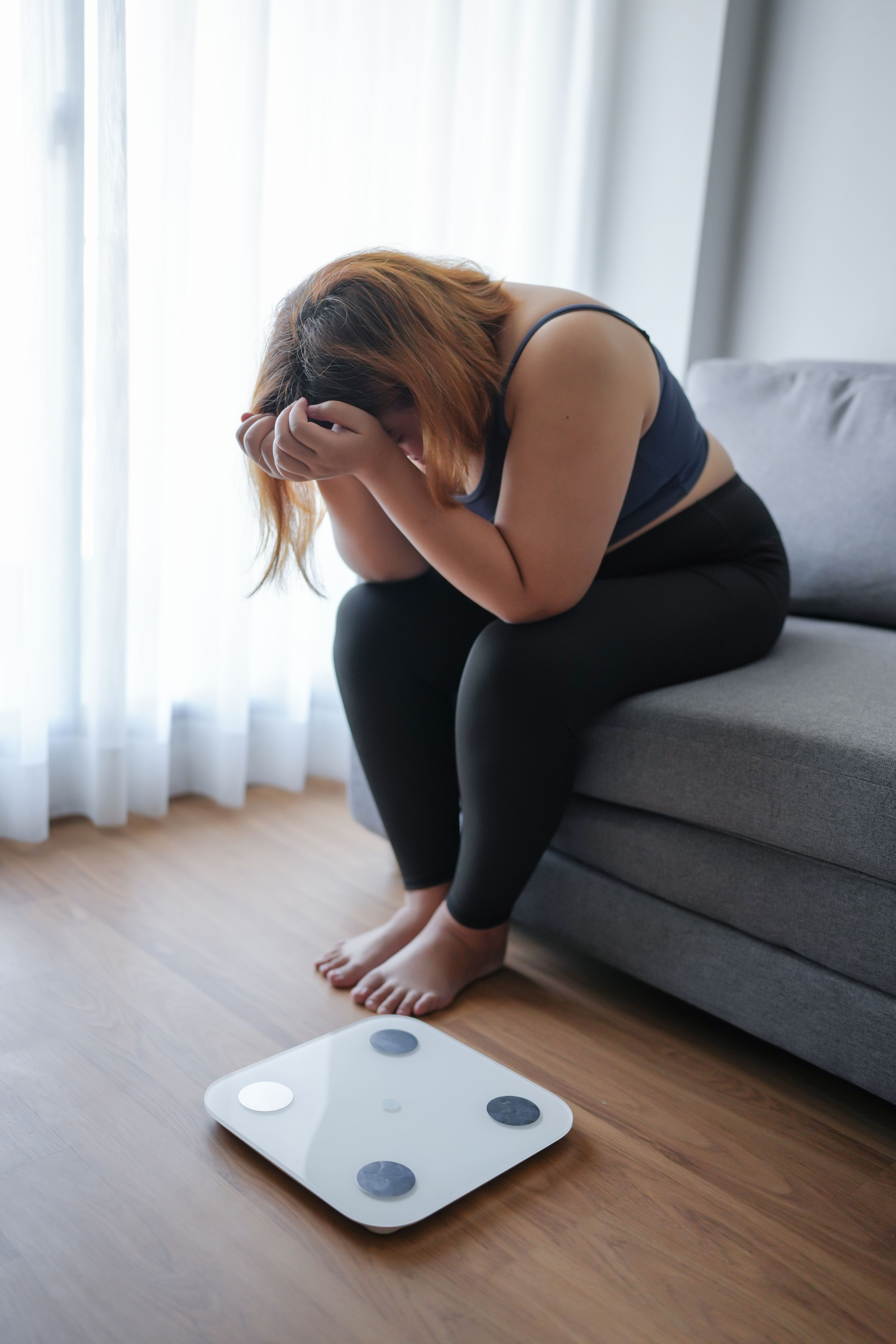 Sad woman with fat upset bored of dieting Weight loss failÂ&nbsp; Fat diet and scale sad asian woman on weight scale at home weight control