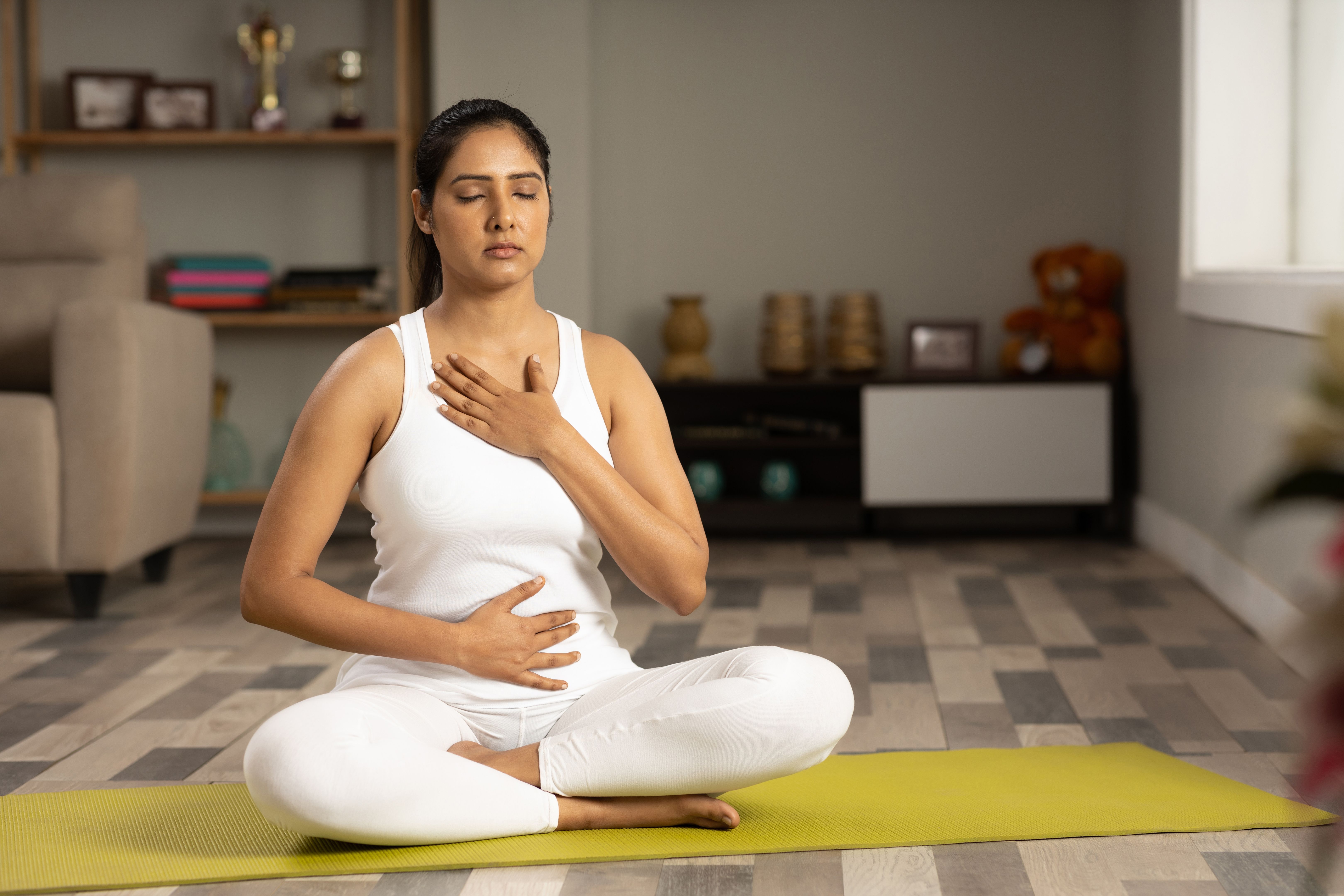 Young woman meditating at home stock photo Young woman meditating at home stock photo