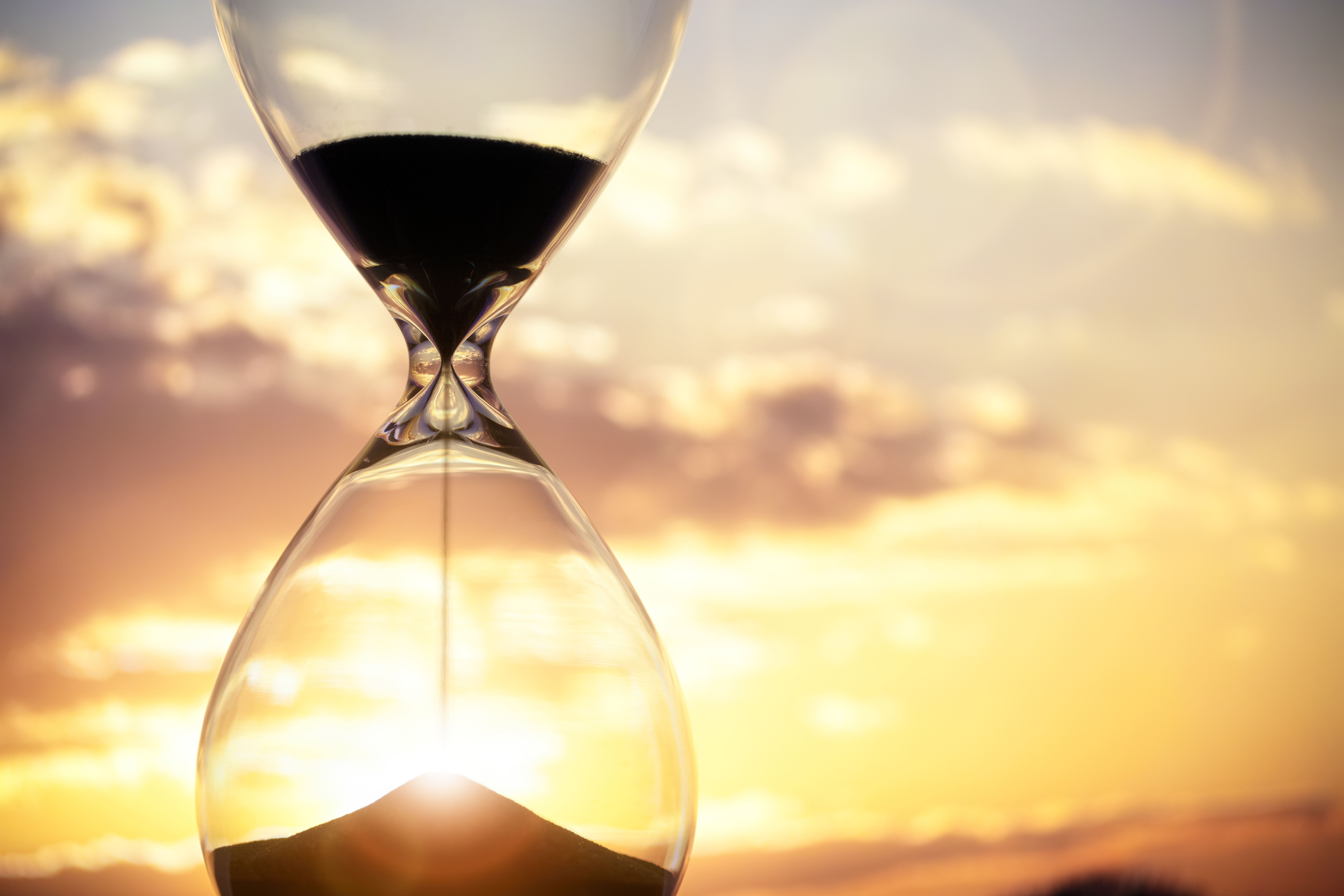 Hourglass at sunset background with copy space