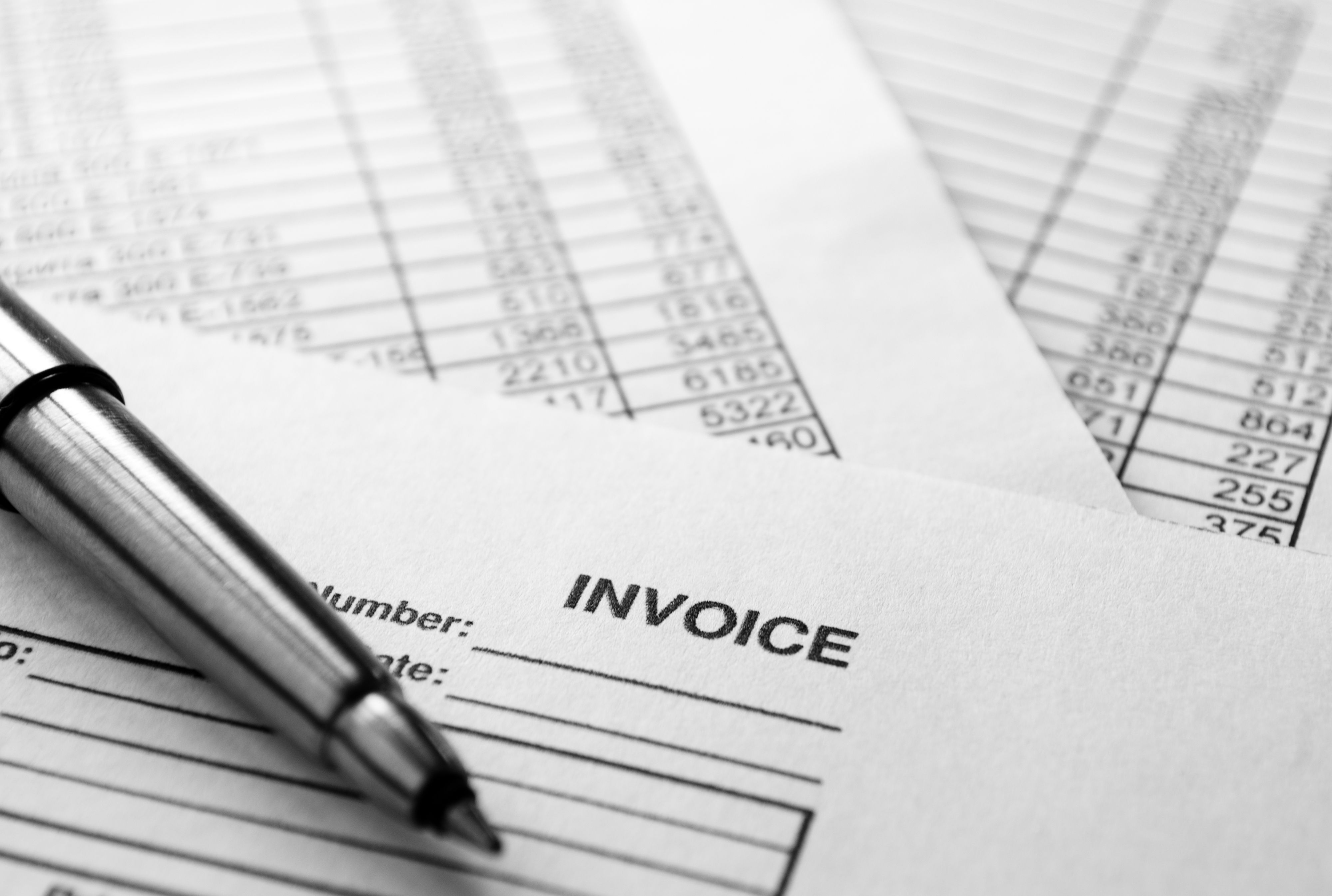 Silver Pen on Top of Sales Reports