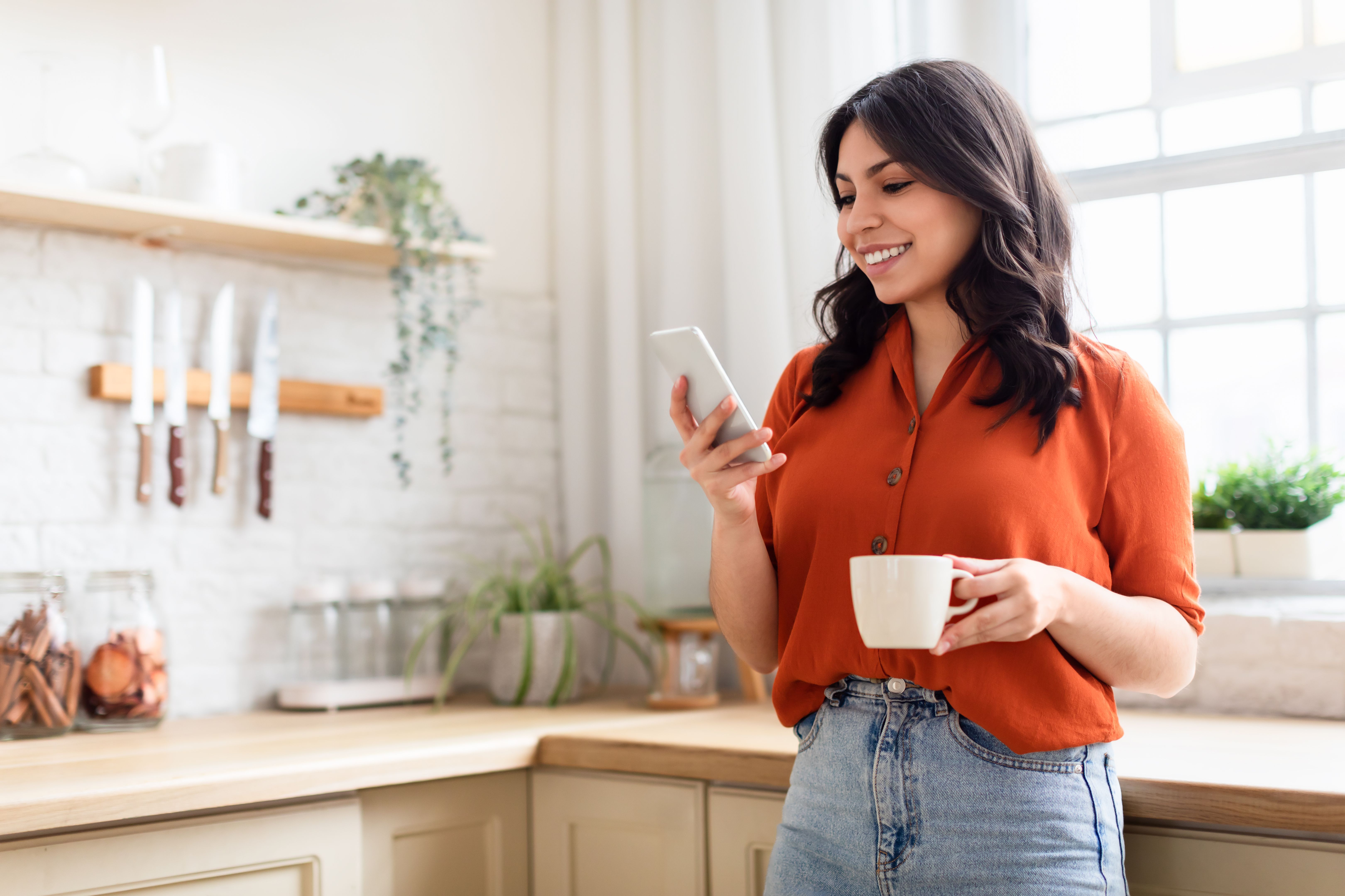 Happy woman with phone and coffee mug