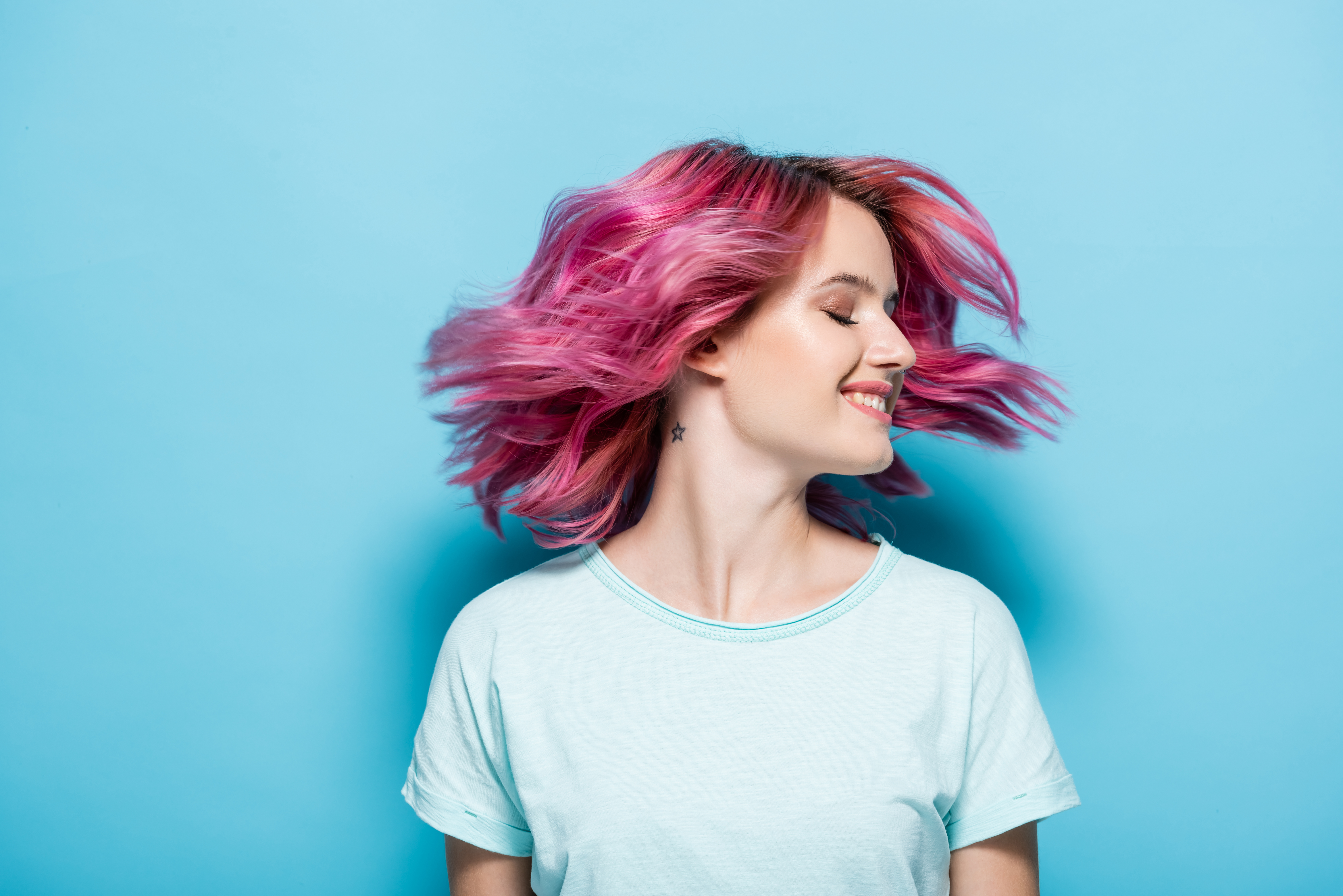 young woman waving pink hair on blue background young woman waving pink hair on blue background