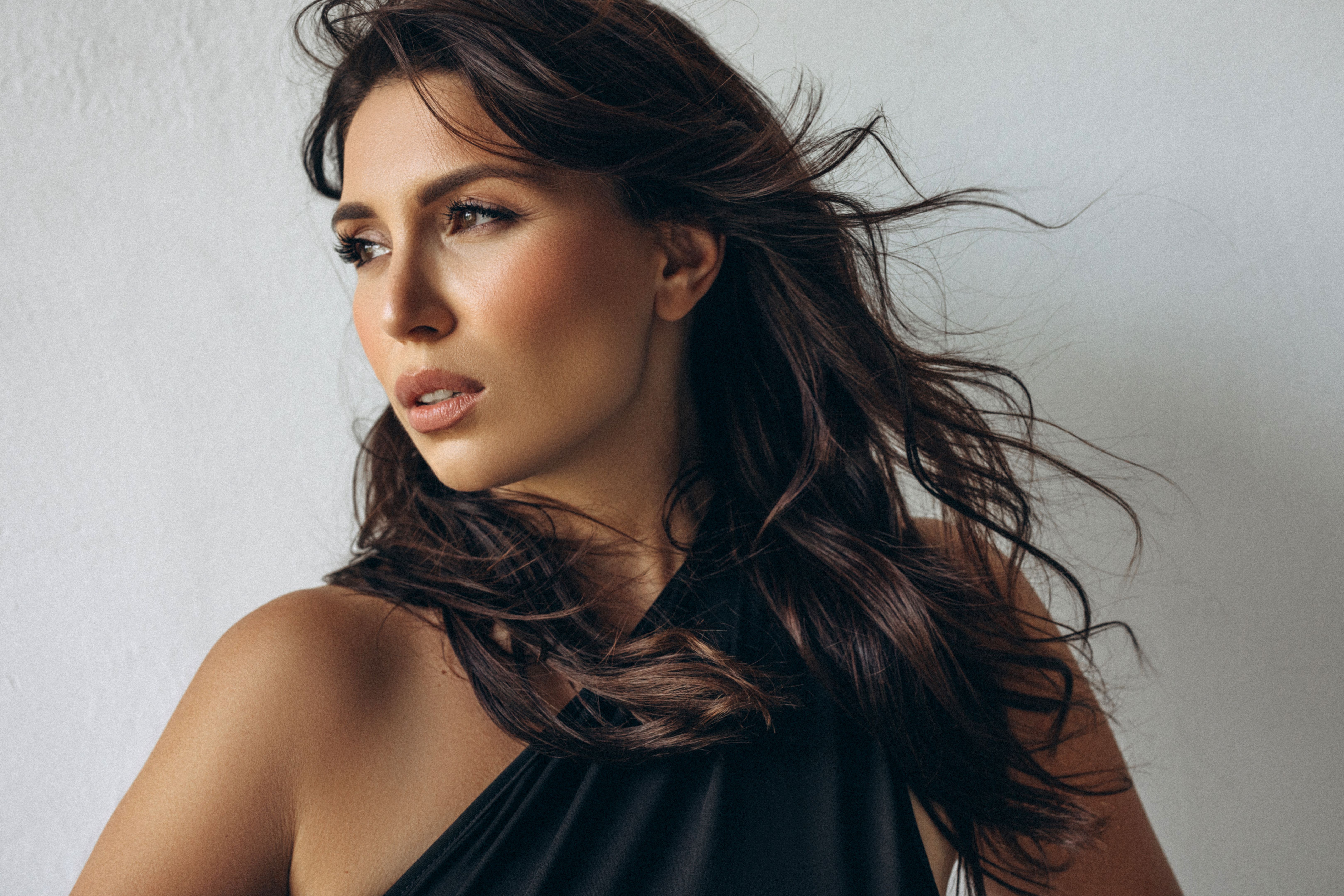 Portrait of a woman with wavy brown hair and elegant expression
