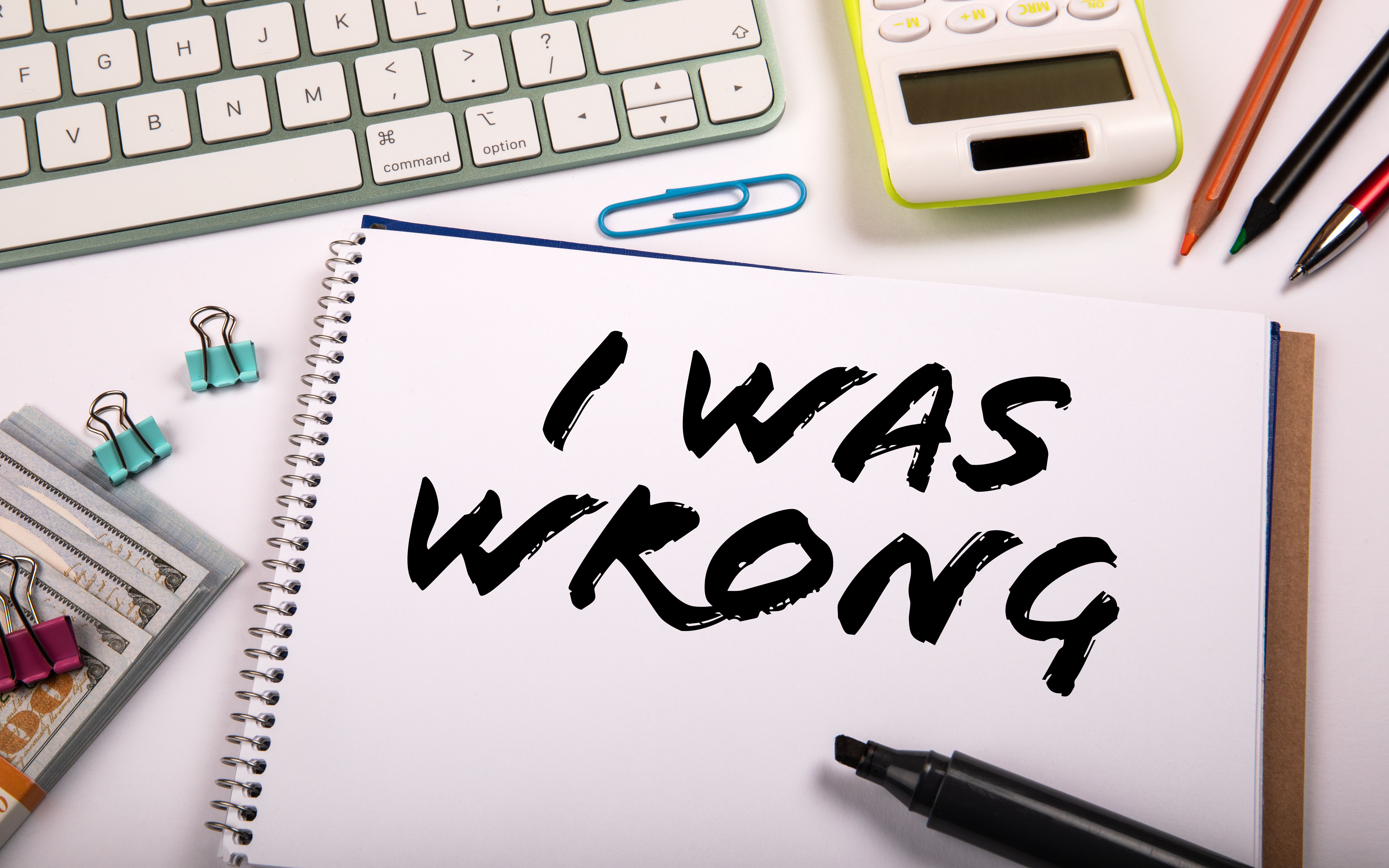 I WAS WRONG . Notepad and computer keyboard on white office table I WAS WRONG . Notepad and computer keyboard on white office table