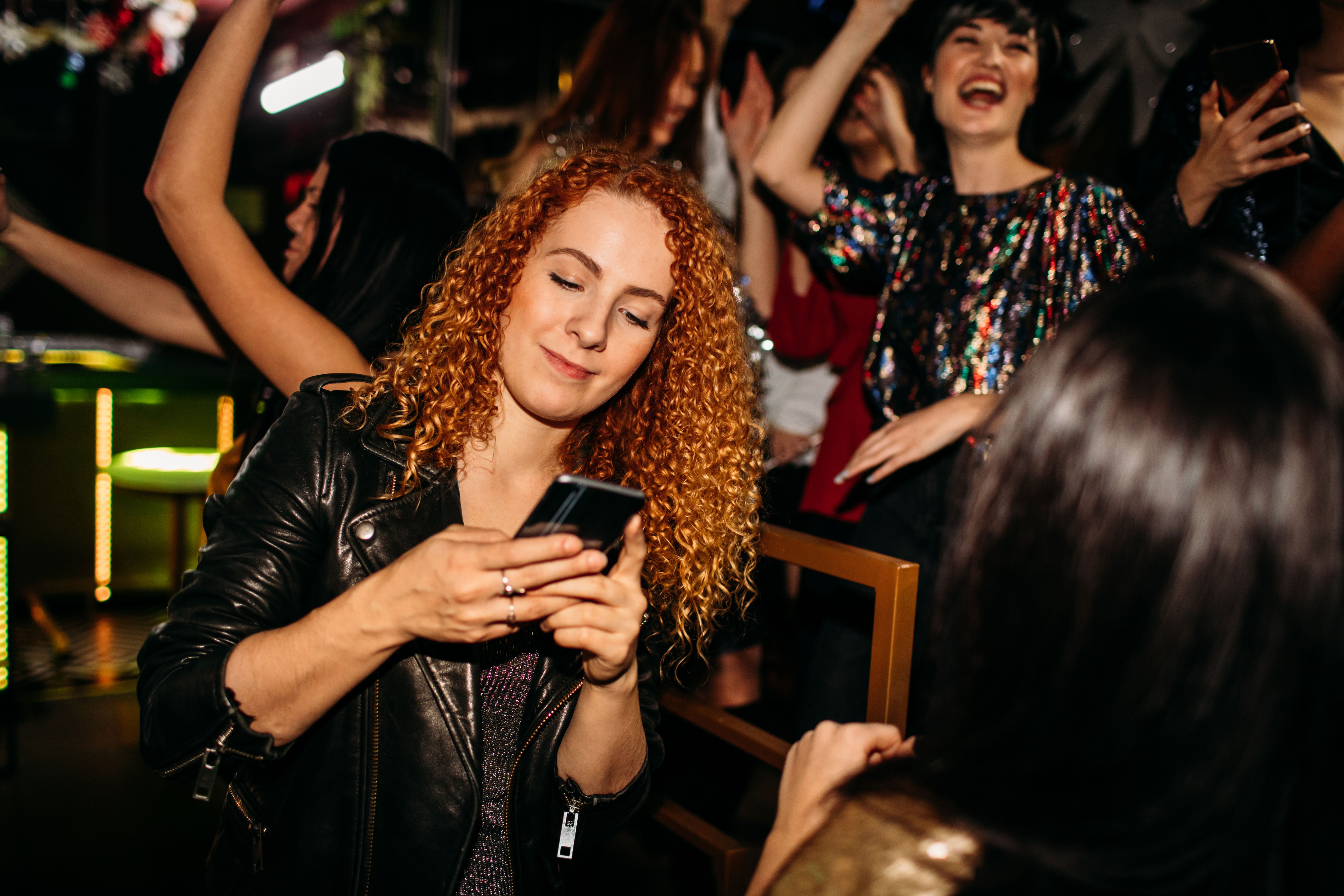 Young Woman Text Messaging In The Night Club