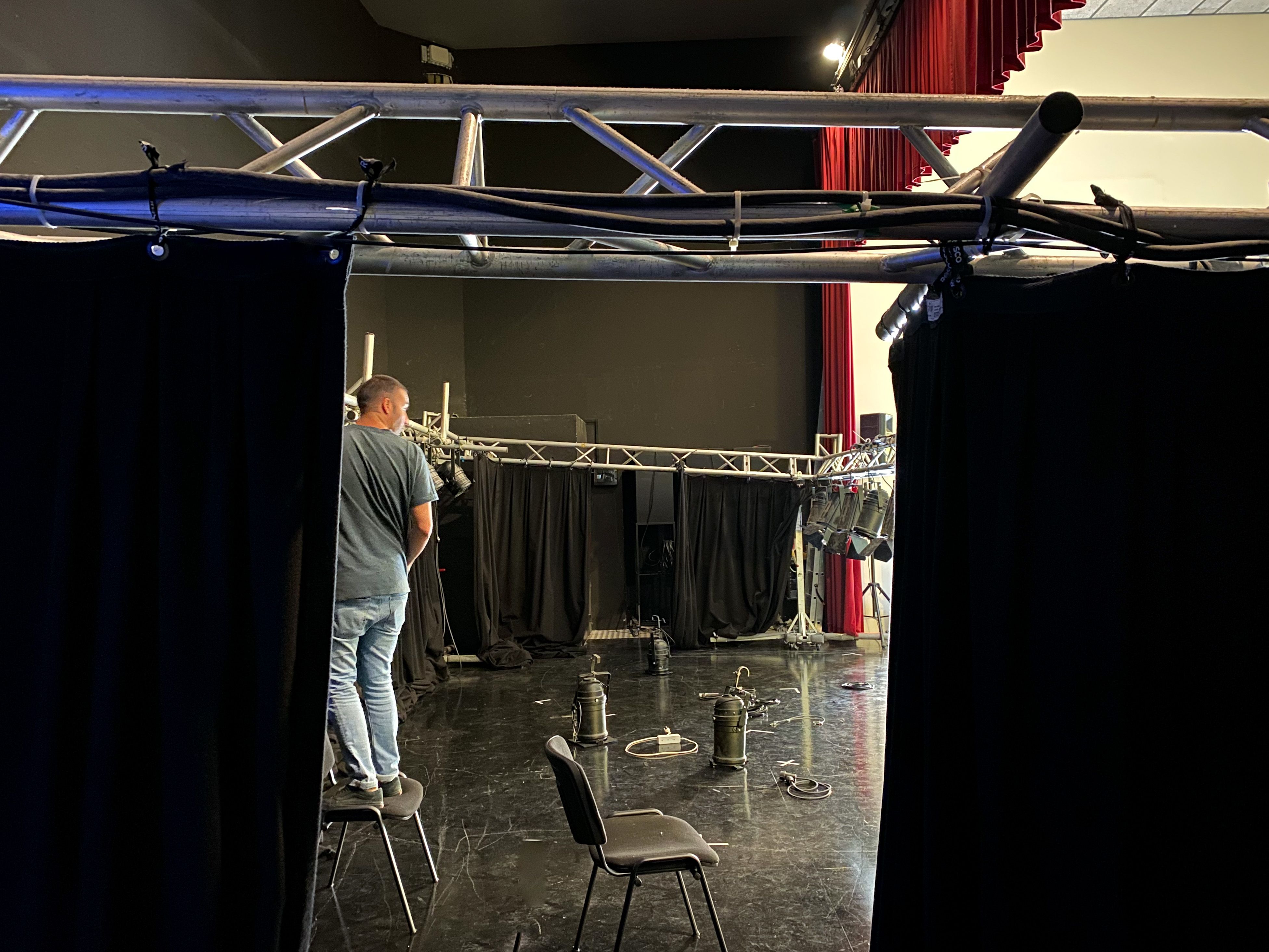 Lighting technician installing spotlights on theater stage