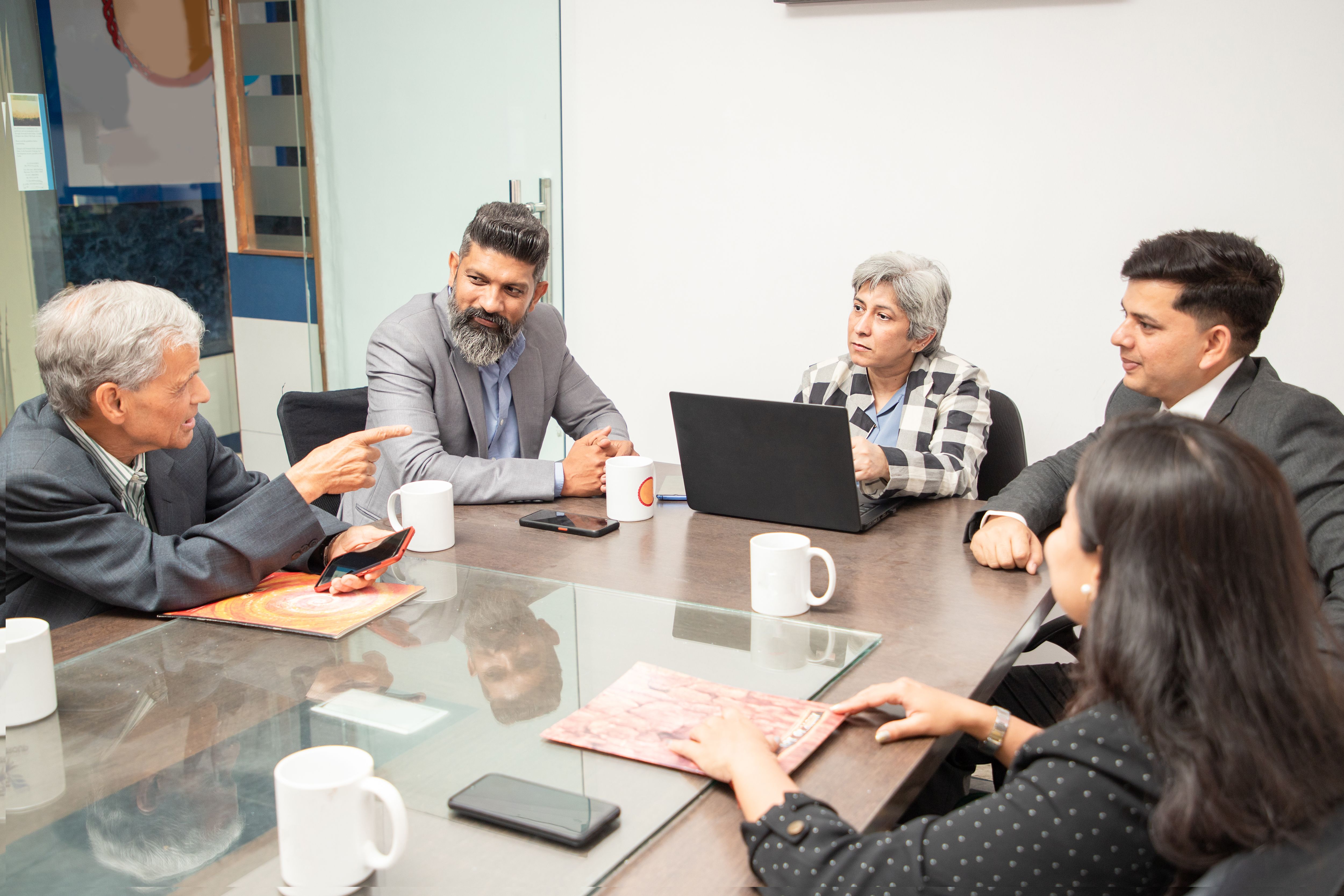 Group of Indian business people having a meeting at conference or board room discussing over new project in office.
