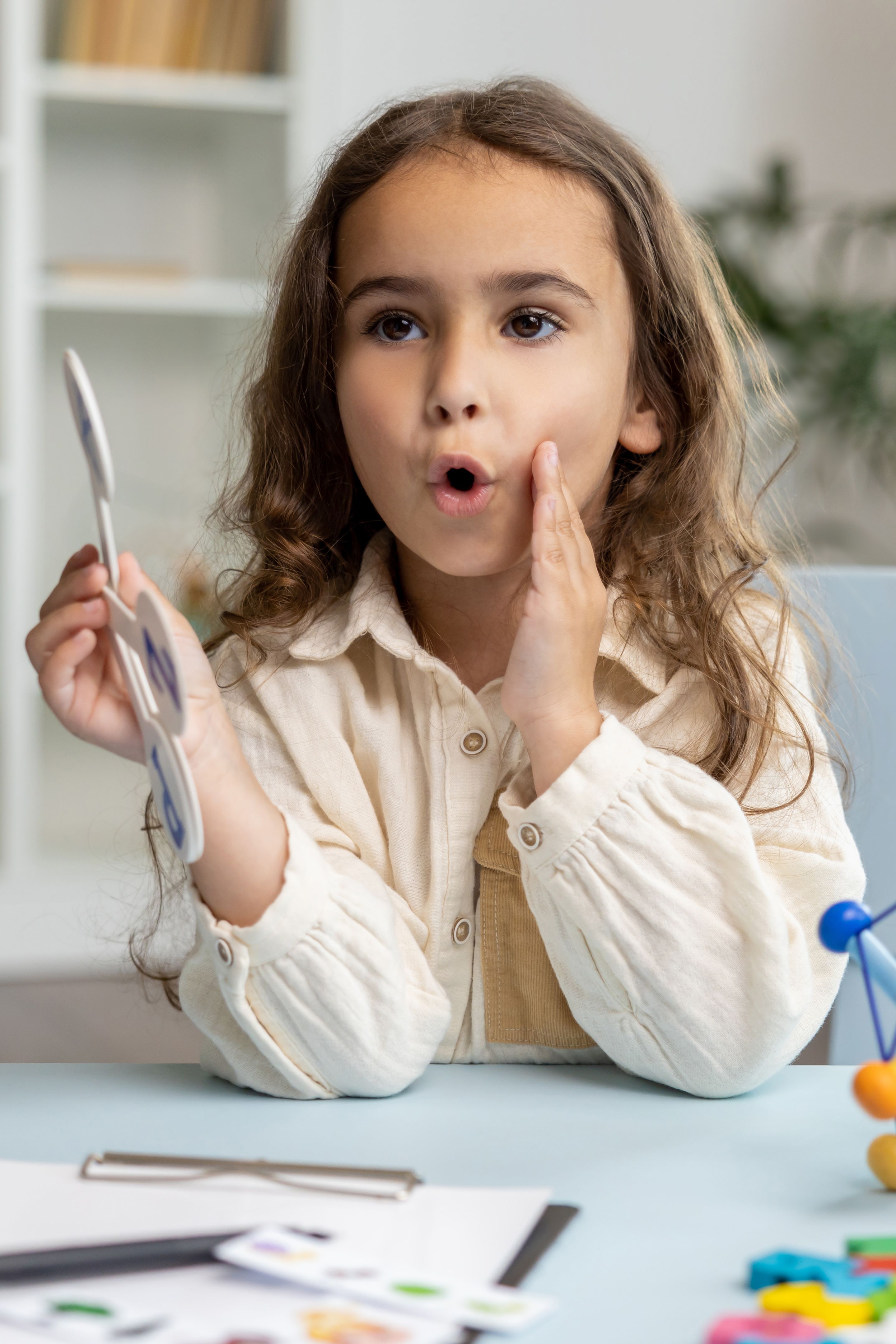 Cute long-haired girl of school girl in the office of a speech therapist