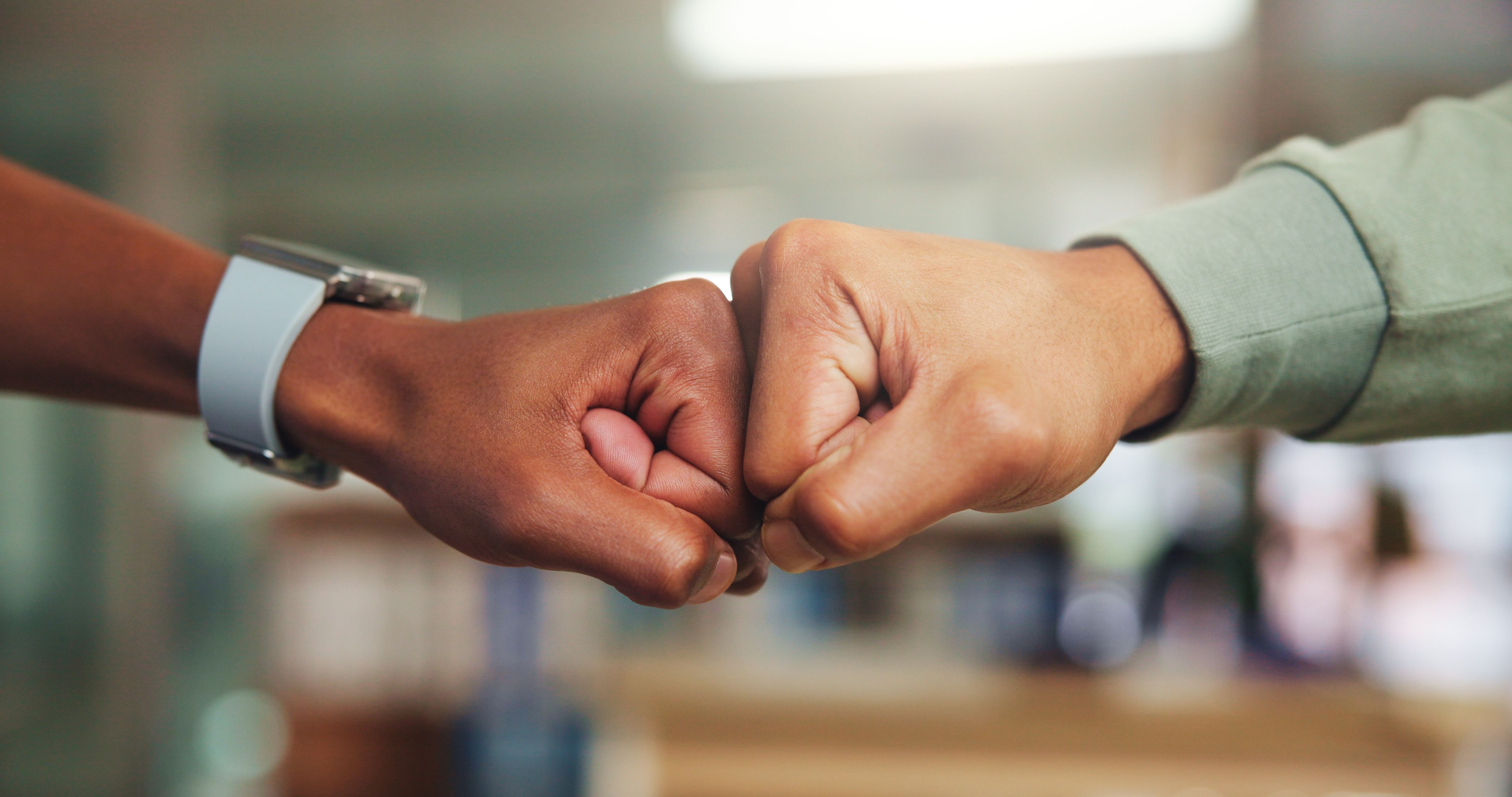 Education, hands and students with fist bump at university for test pass, exam results or support. Achievement, college and people with gesture on campus for assignment goal and scholarship approval