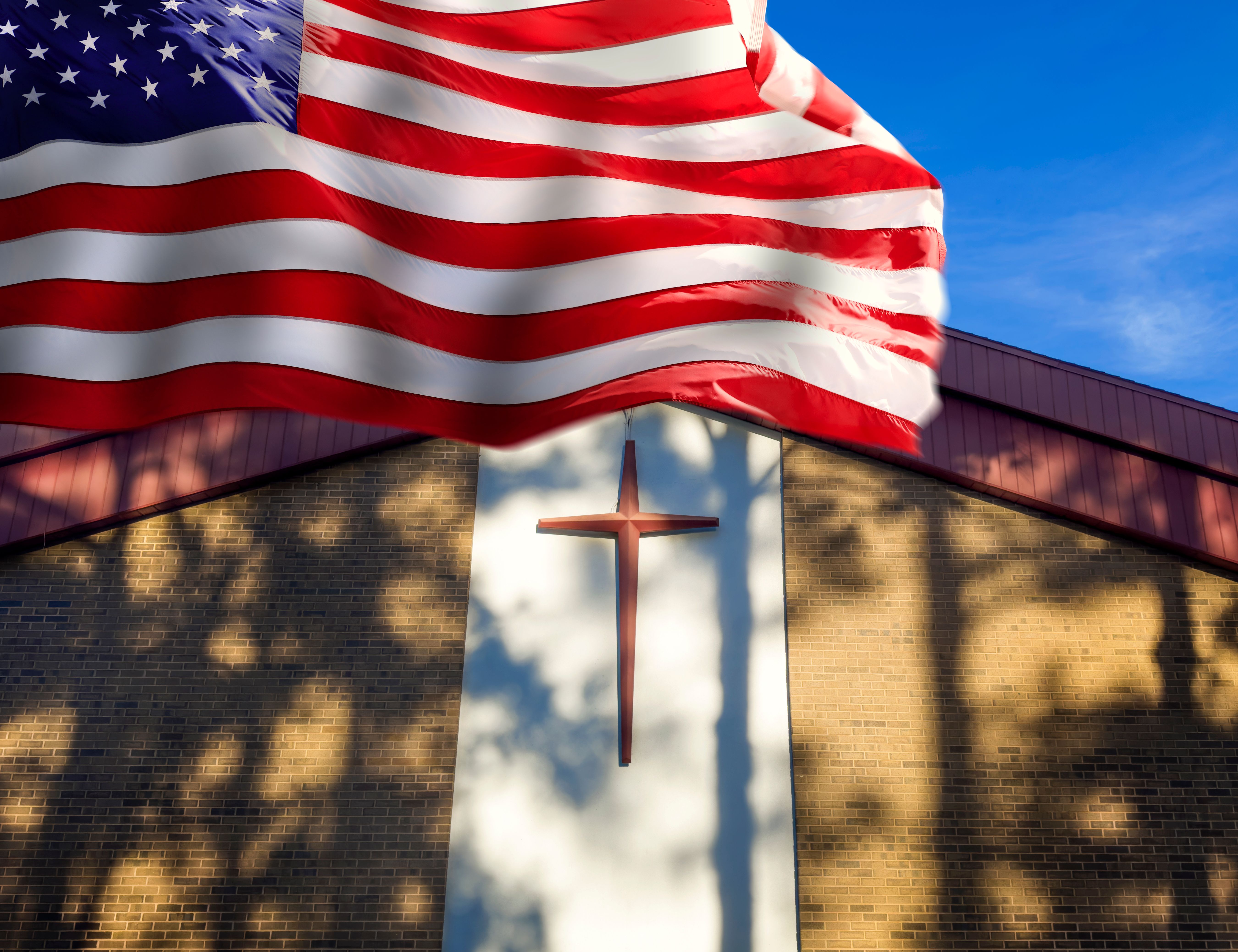 American flag with religious cross on church wall
