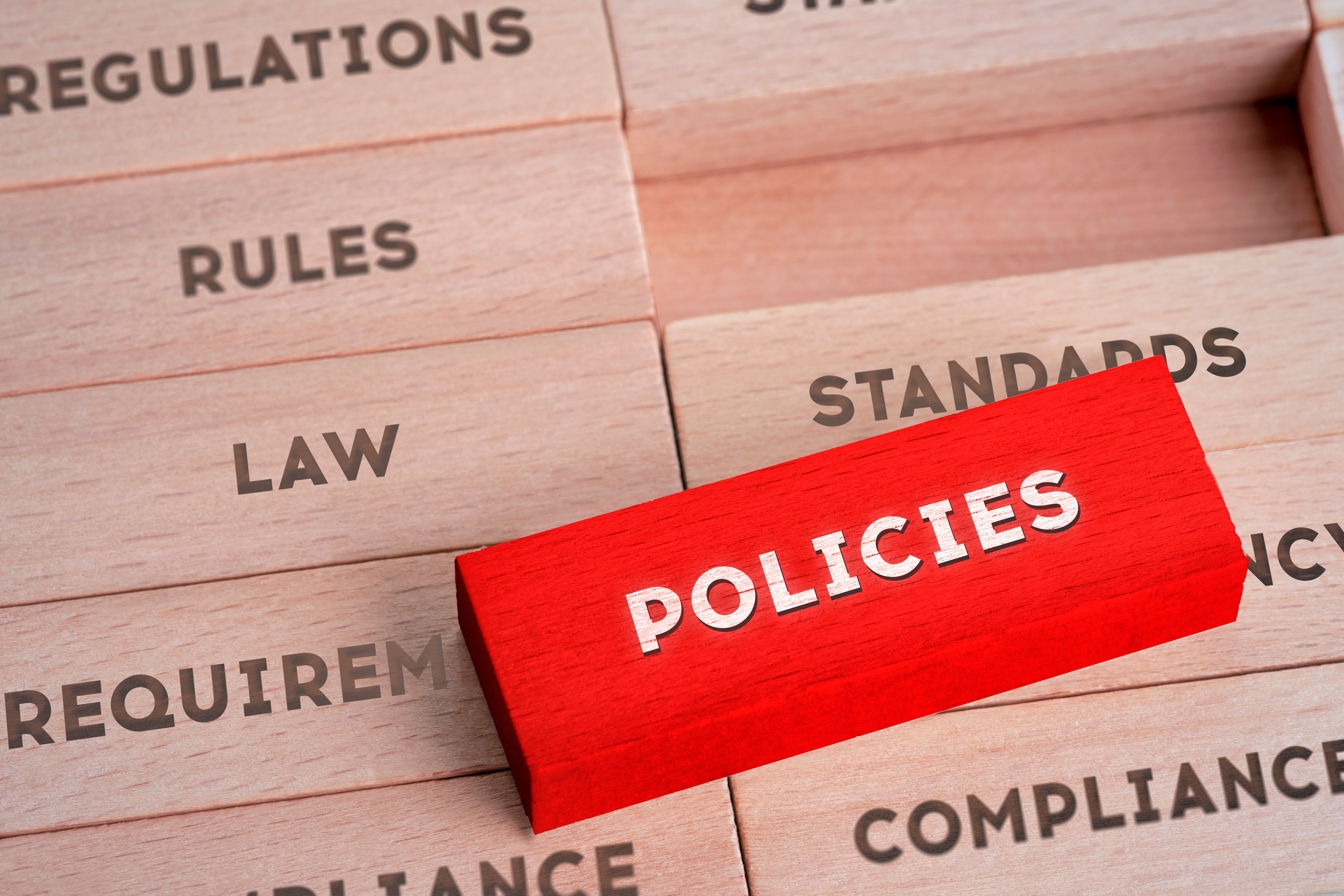 Policies Concept with Wooden Blocks in Red Color