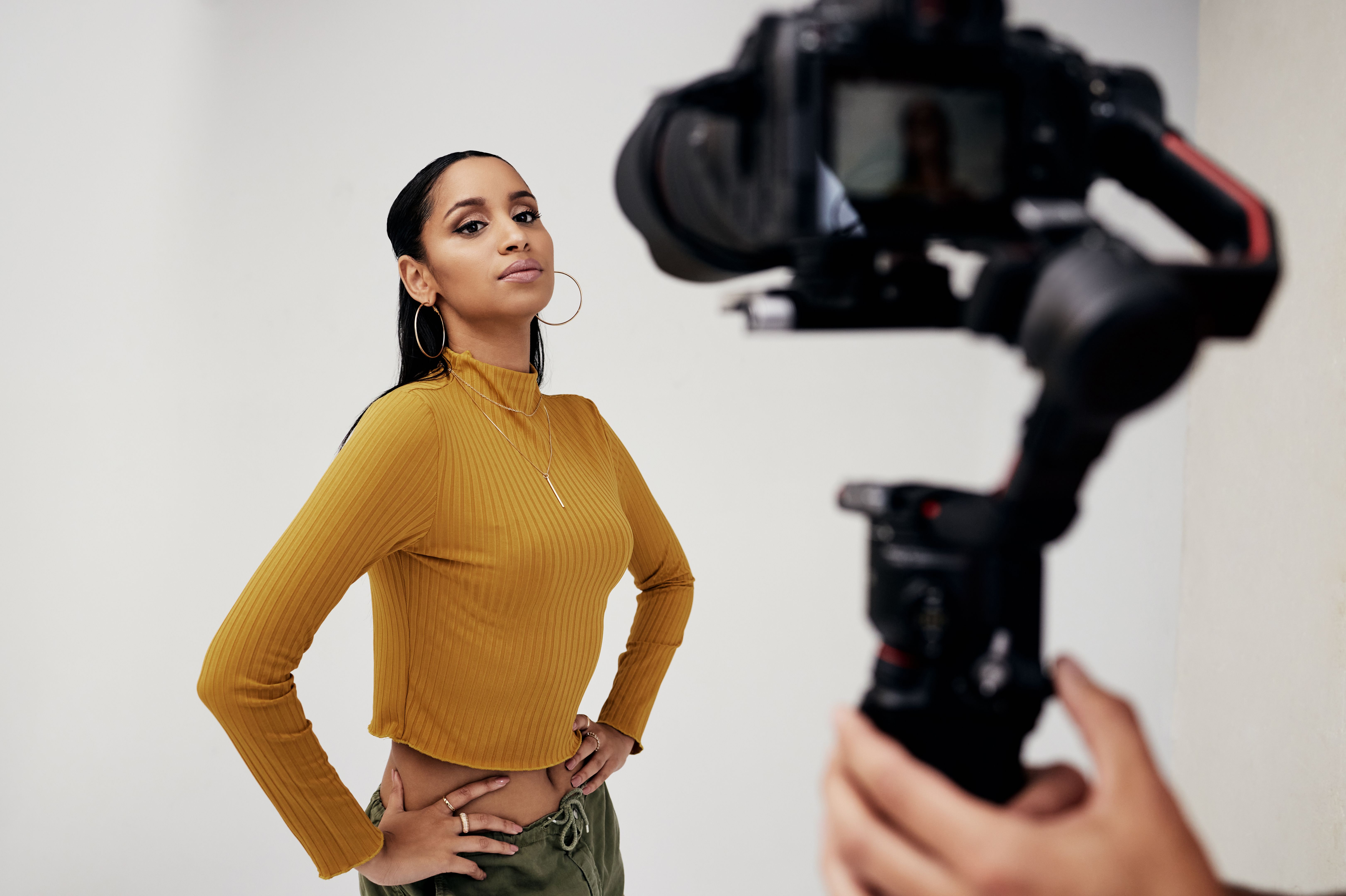 Photography, woman and cameraman or photographer with fashion model in studio for creative, capture and shoot. Media, backstage and professional man with camera, equipment and girl for photoshoot