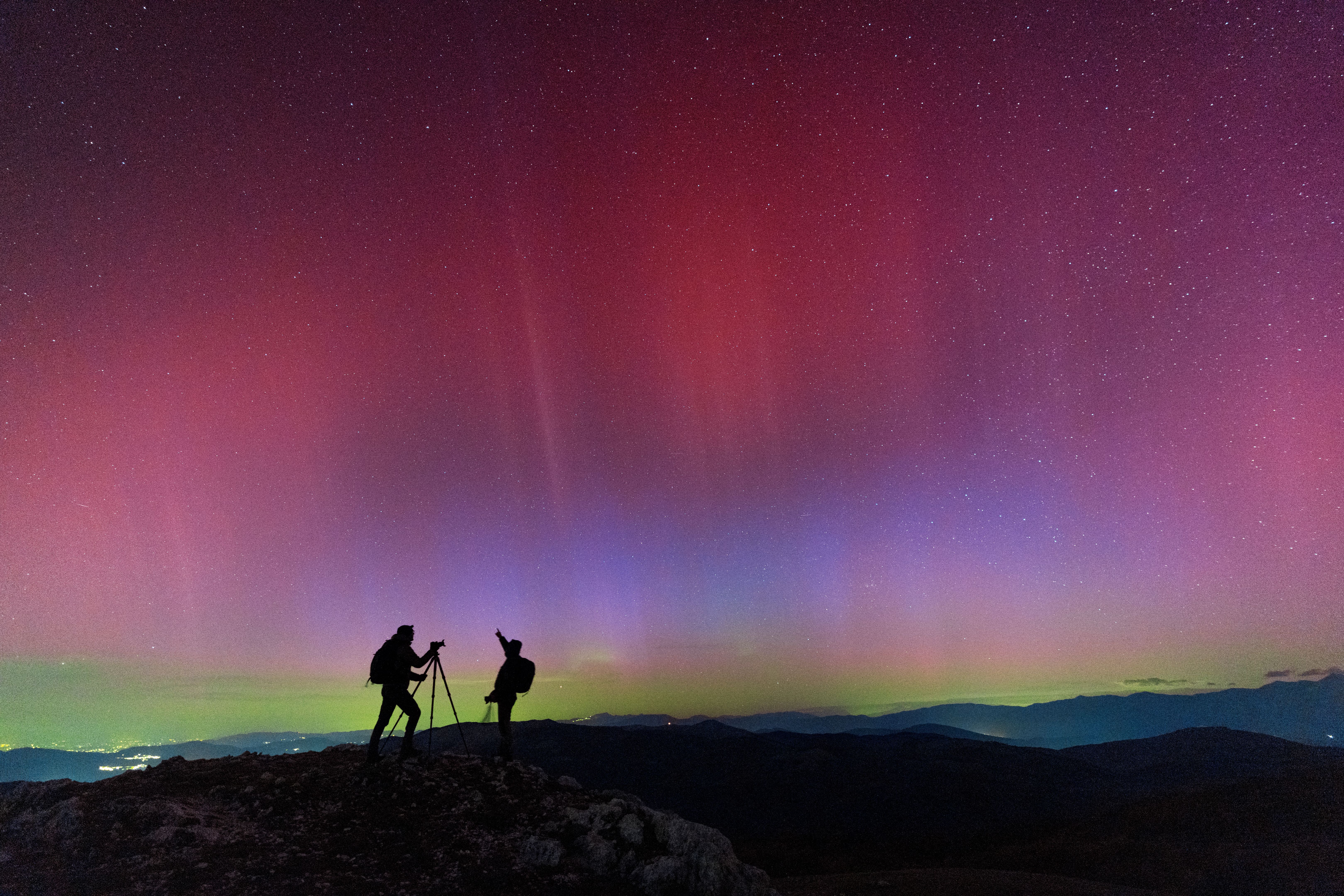 People photographing northern lights (aurora borealis) dancing in the italian sky, Apennines, Italy People photographing northern lights (aurora borealis) dancing in the italian sky, Apennines, Italy