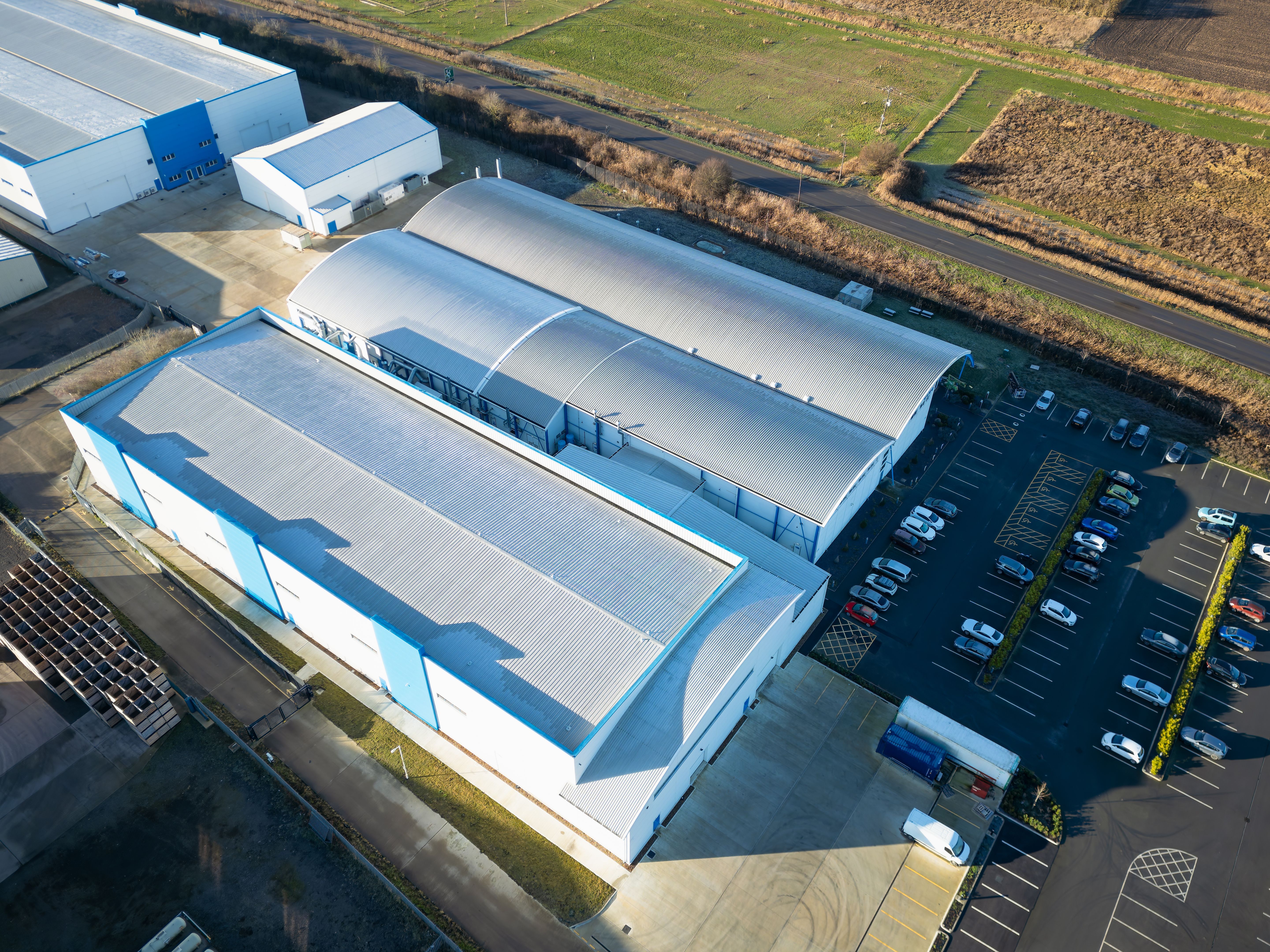 Interesting aerial view of a modern, metal clad industrial building used as a new technology manufacturing facility in the UK.