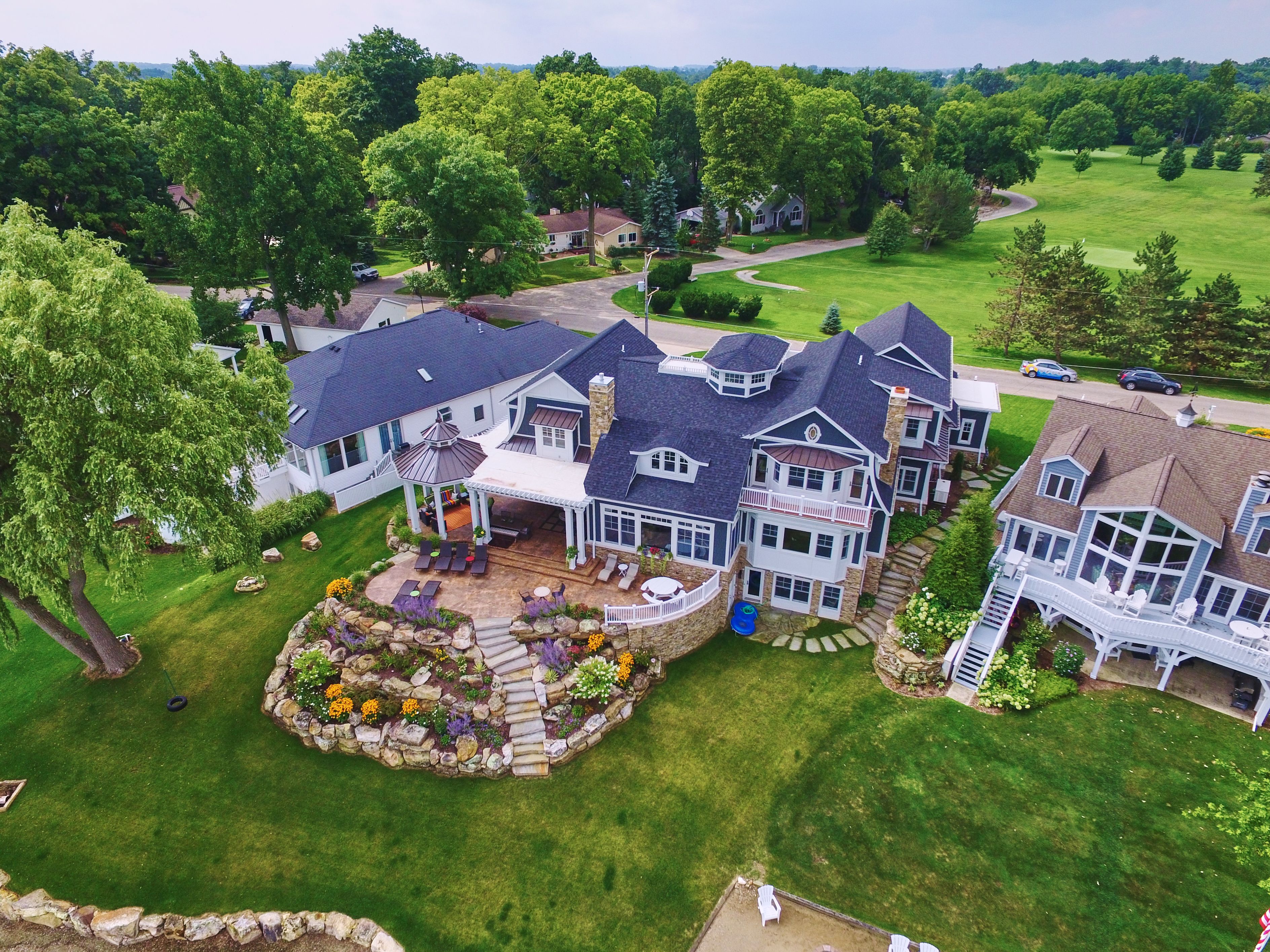 Aerial View of Upscale Suburban Homes with Lush Gardens and Golf Course