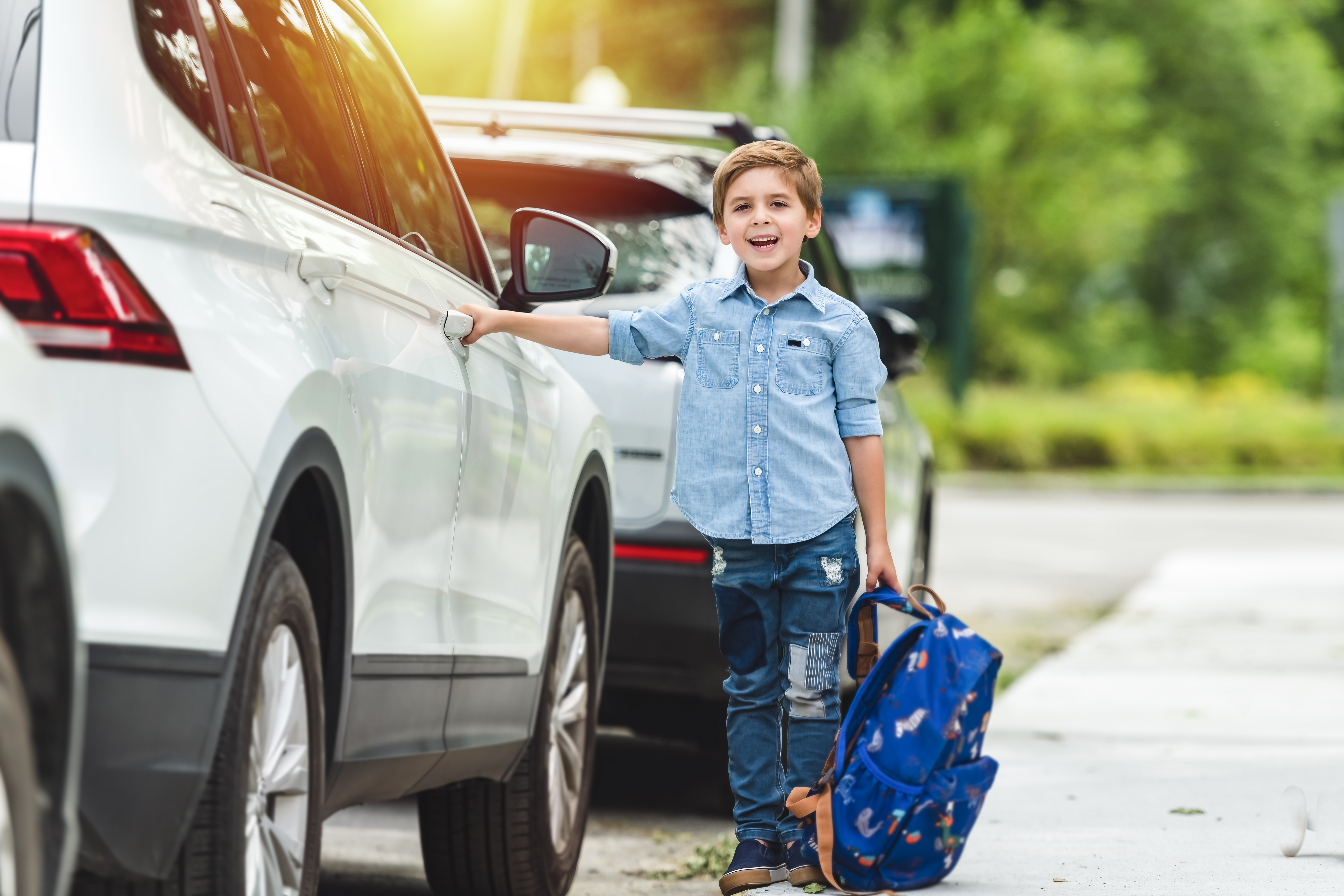 Smart little child with backpack on the school playground.