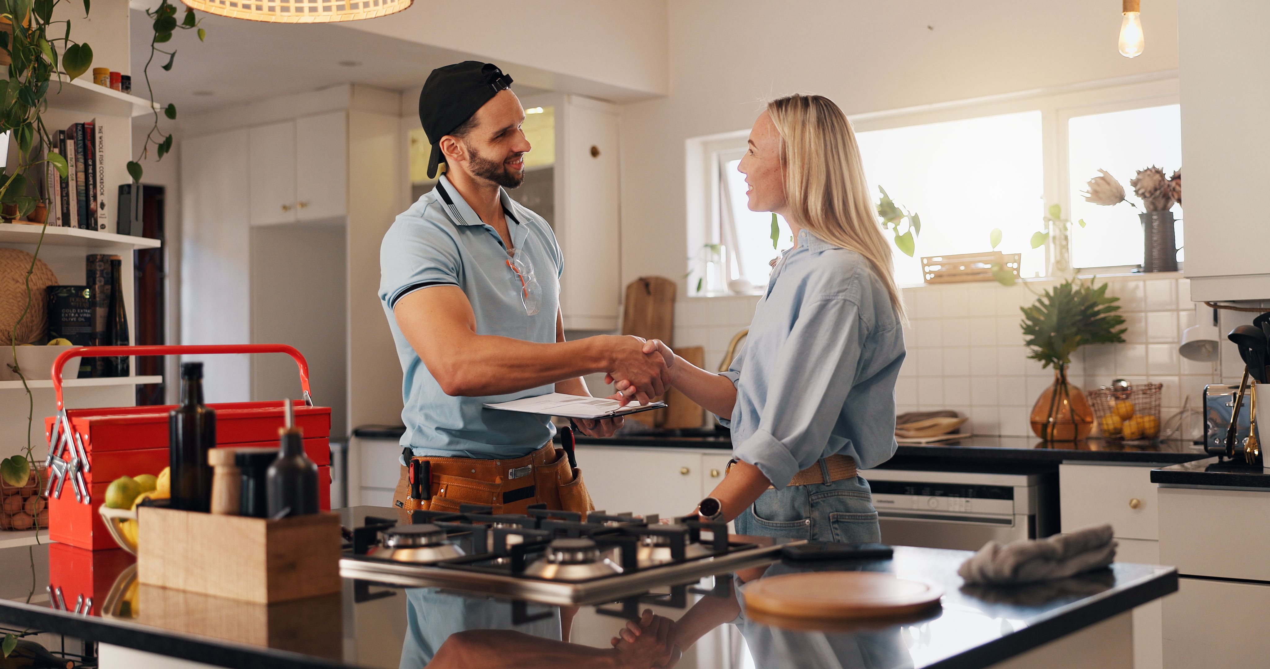 Woman, man and plumber with handshake in kitchen for thanks, report or deal for repair at house. People, handyman and client with shaking hands for service with smile, inspection or leak at apartment