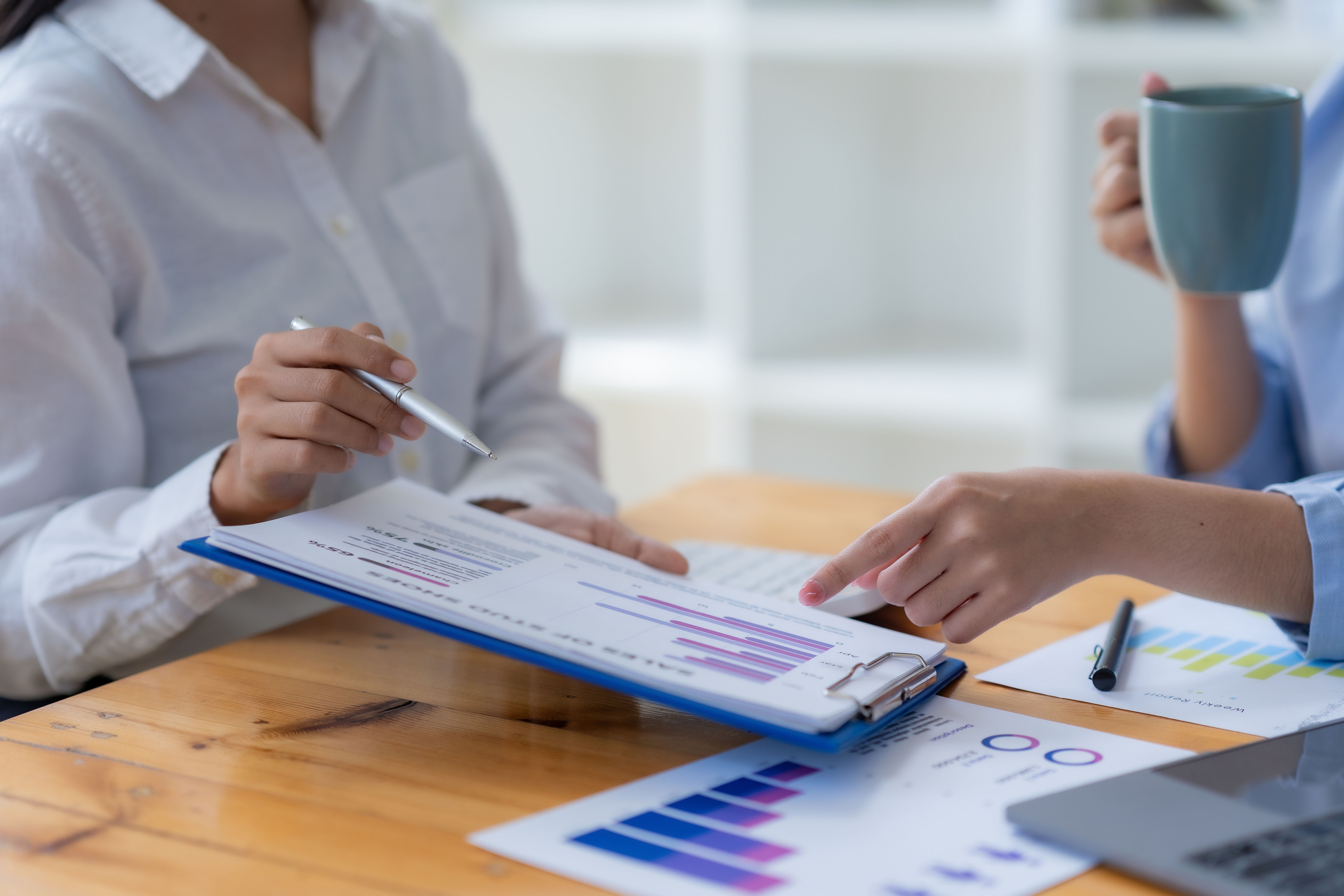 Businesswoman pointing at financial data graph in office meeting