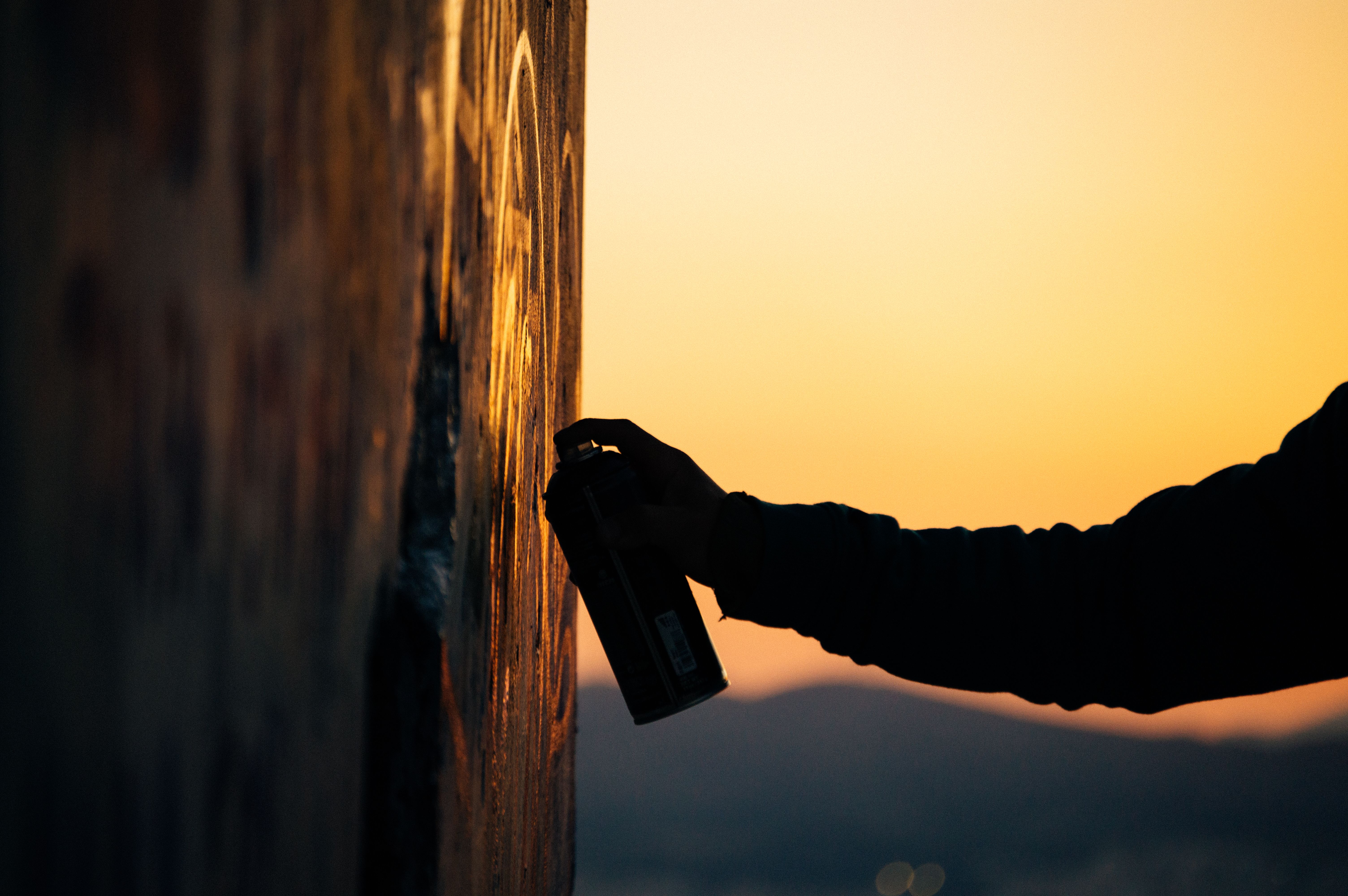 Graffiti-Workshop in Stuttgart bei Sonnenuntergang – Teilnehmer:innen sprayen unter Anleitung von Open Mike in urbaner Kulisse.