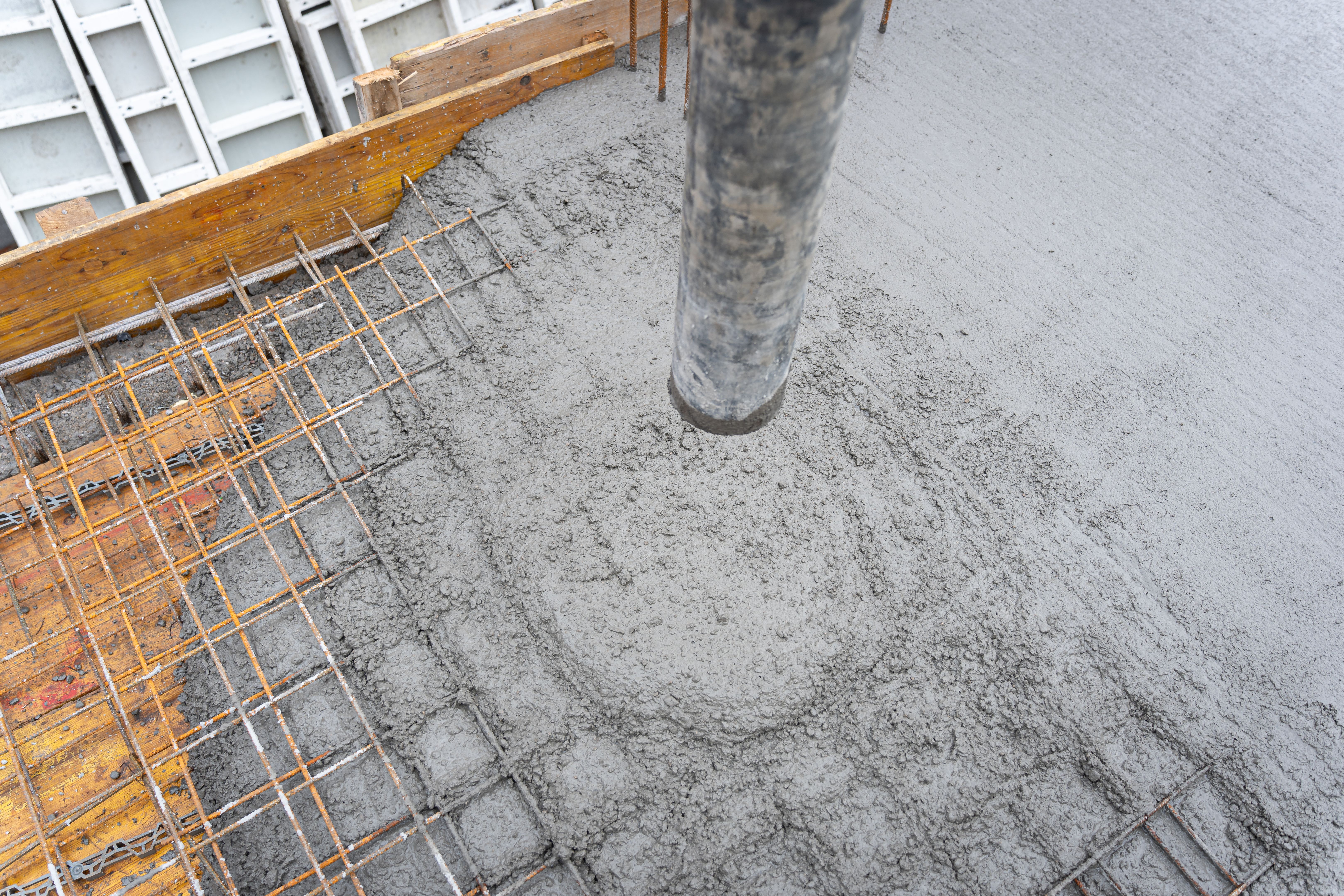 Reinforcing bars with wet cement in the process of pouring a concrete floor