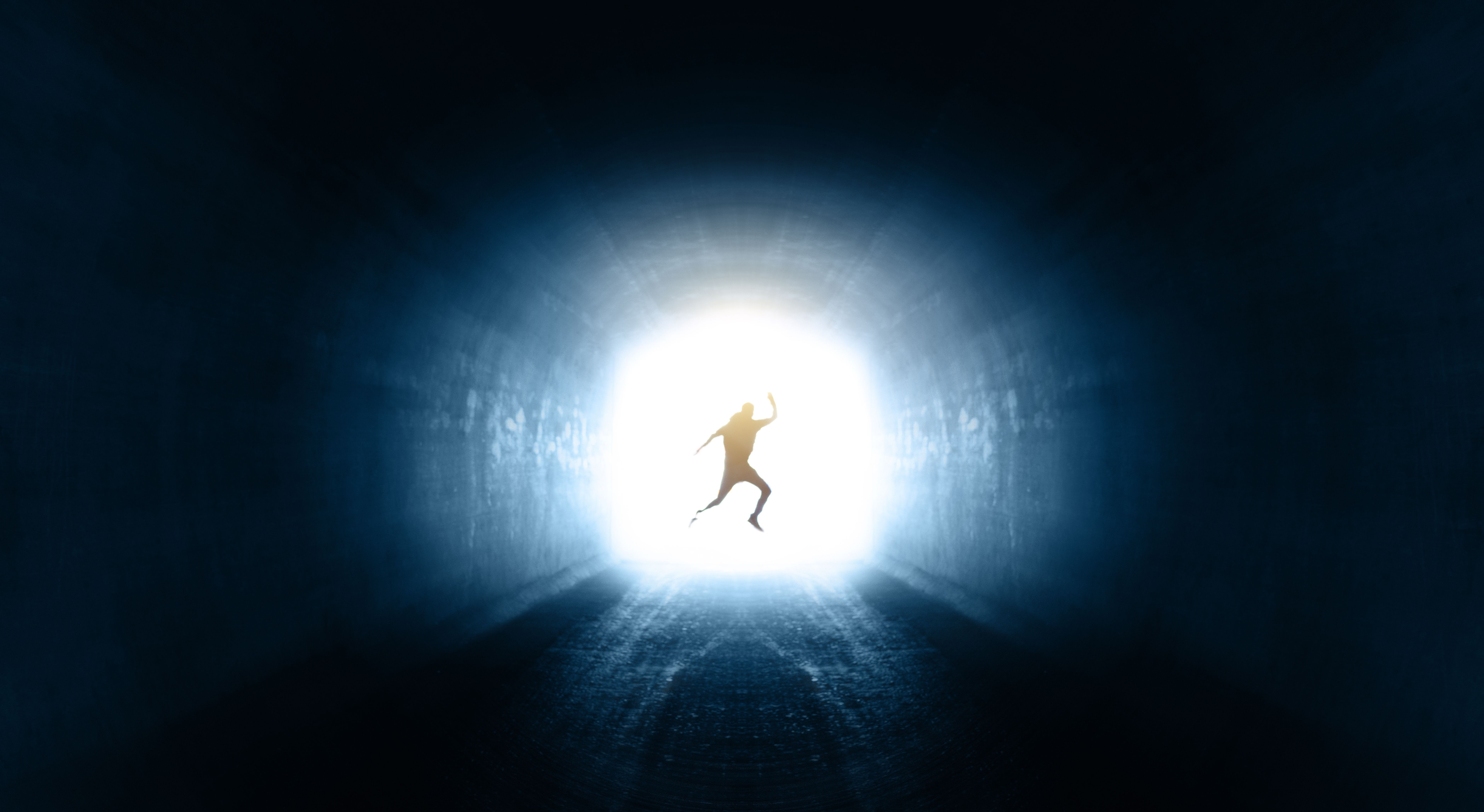 Single man jumping at the end of the tunnel