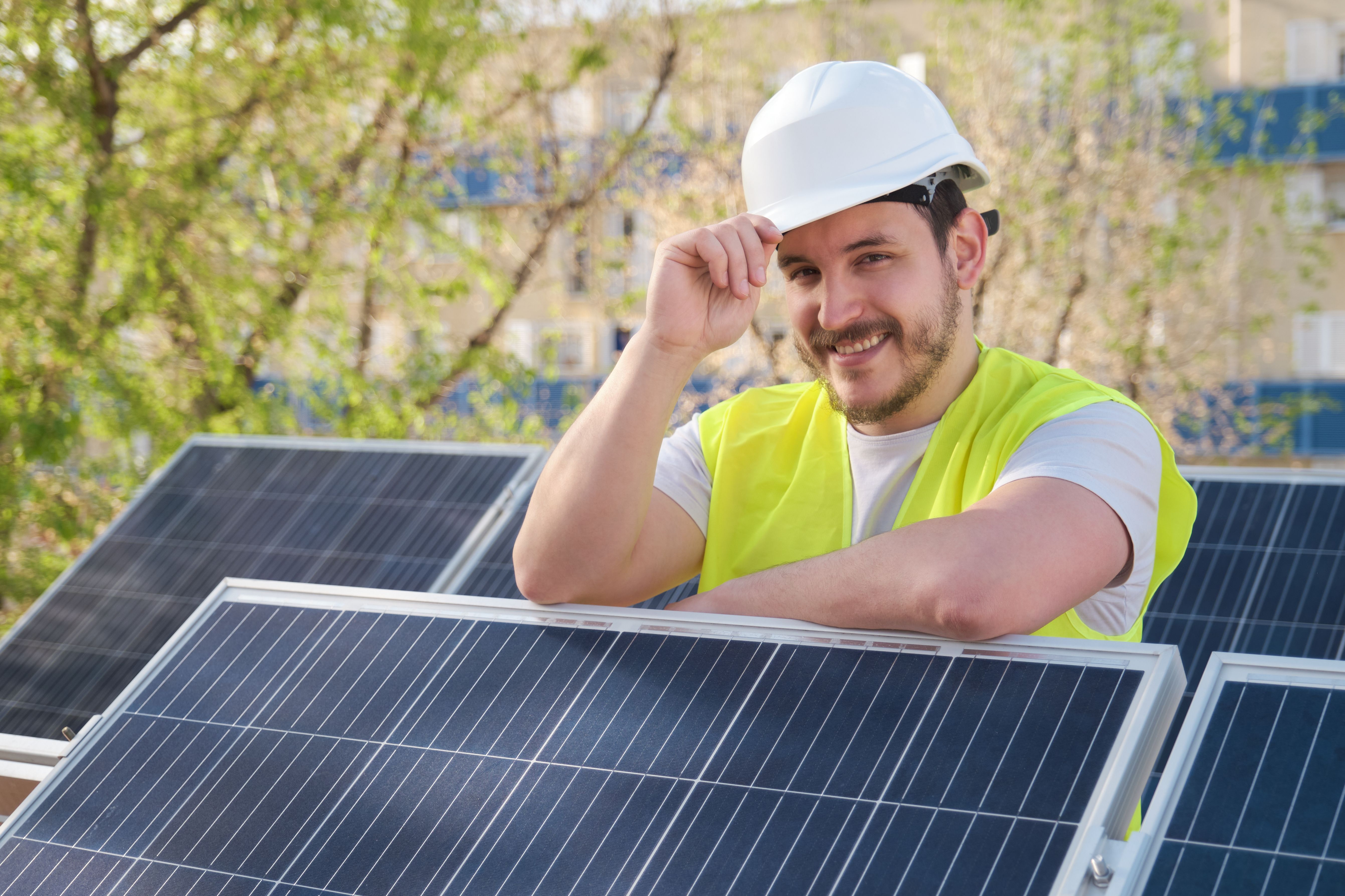 Solar panels technician looking at camera after installing photovoltaic station.