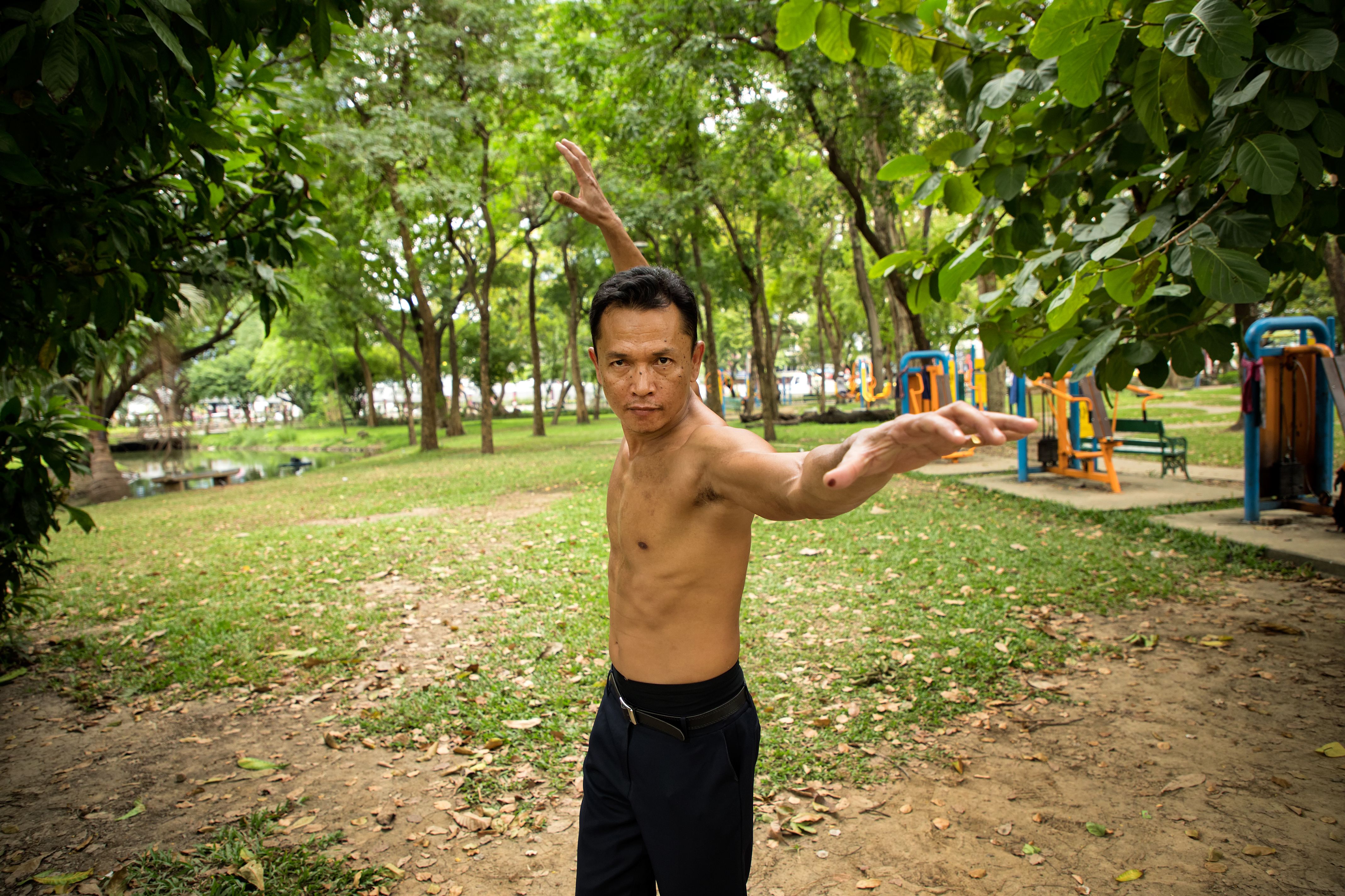 Young adult asian man exercising and relaxing at public park