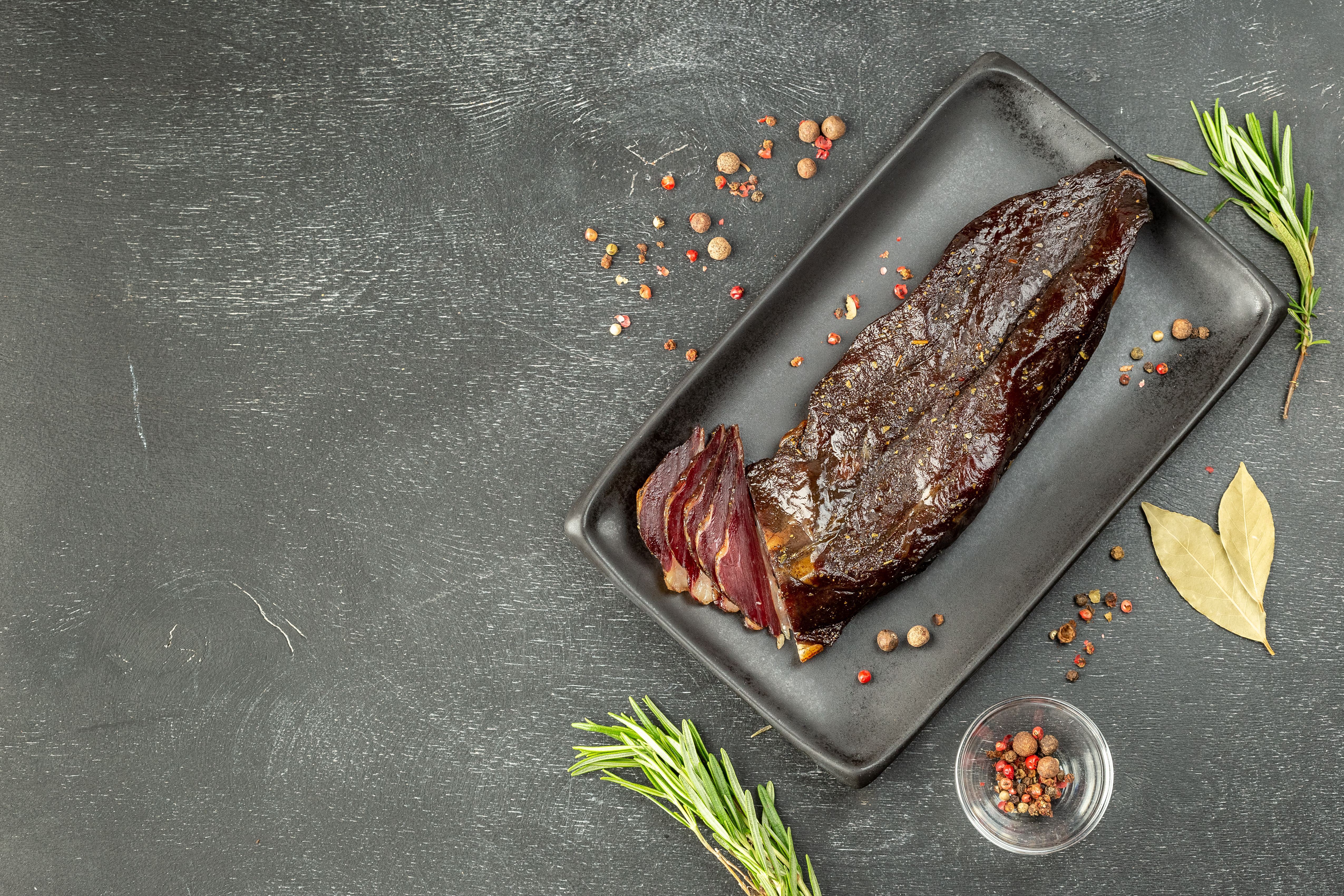 Smoked sliced duck breast on black plate Smoked sliced duck breast on black plate