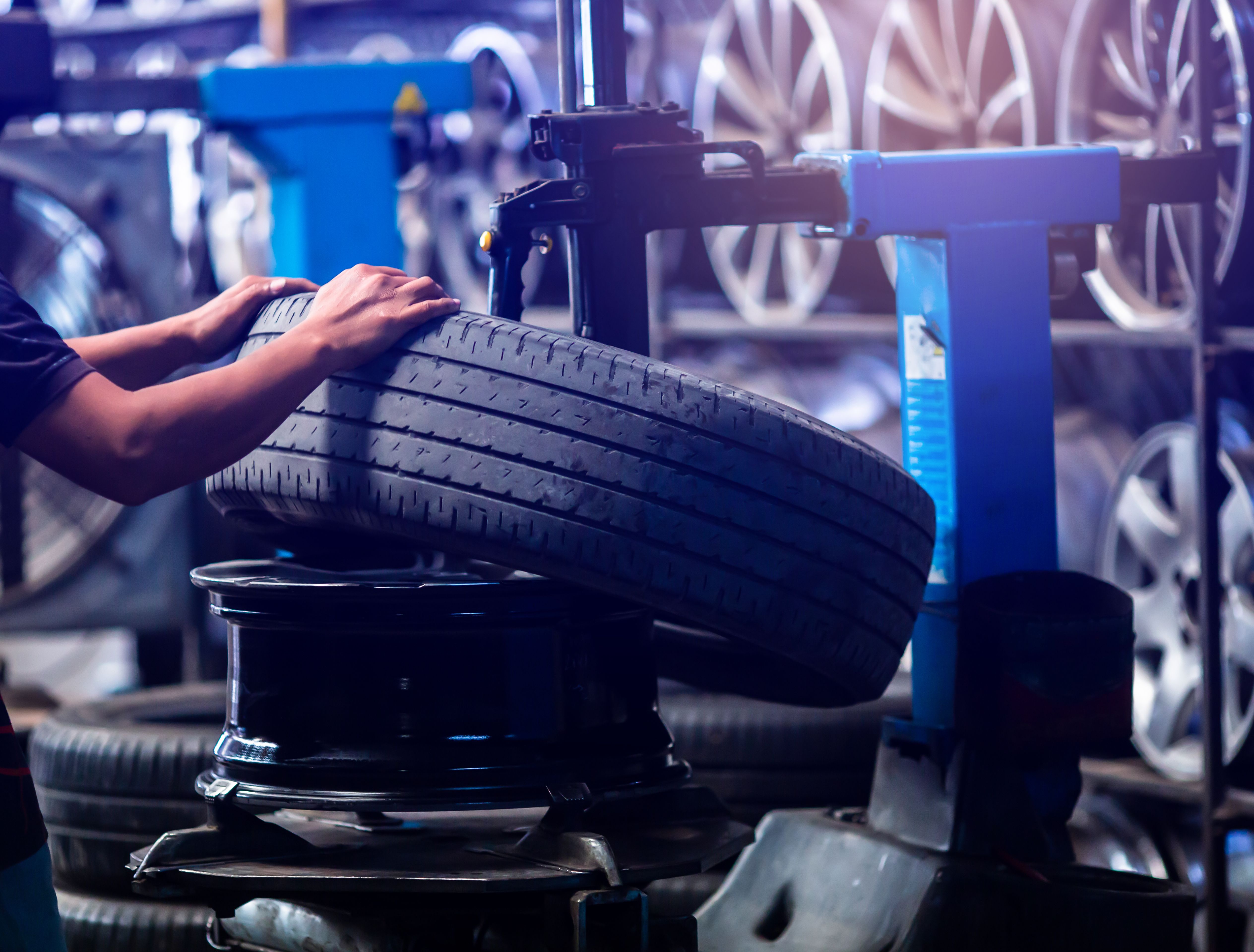 Selective focus to engineer balancing car wheel on balancer in workshop. Mechanic. Mechanic repairing a car wheel.