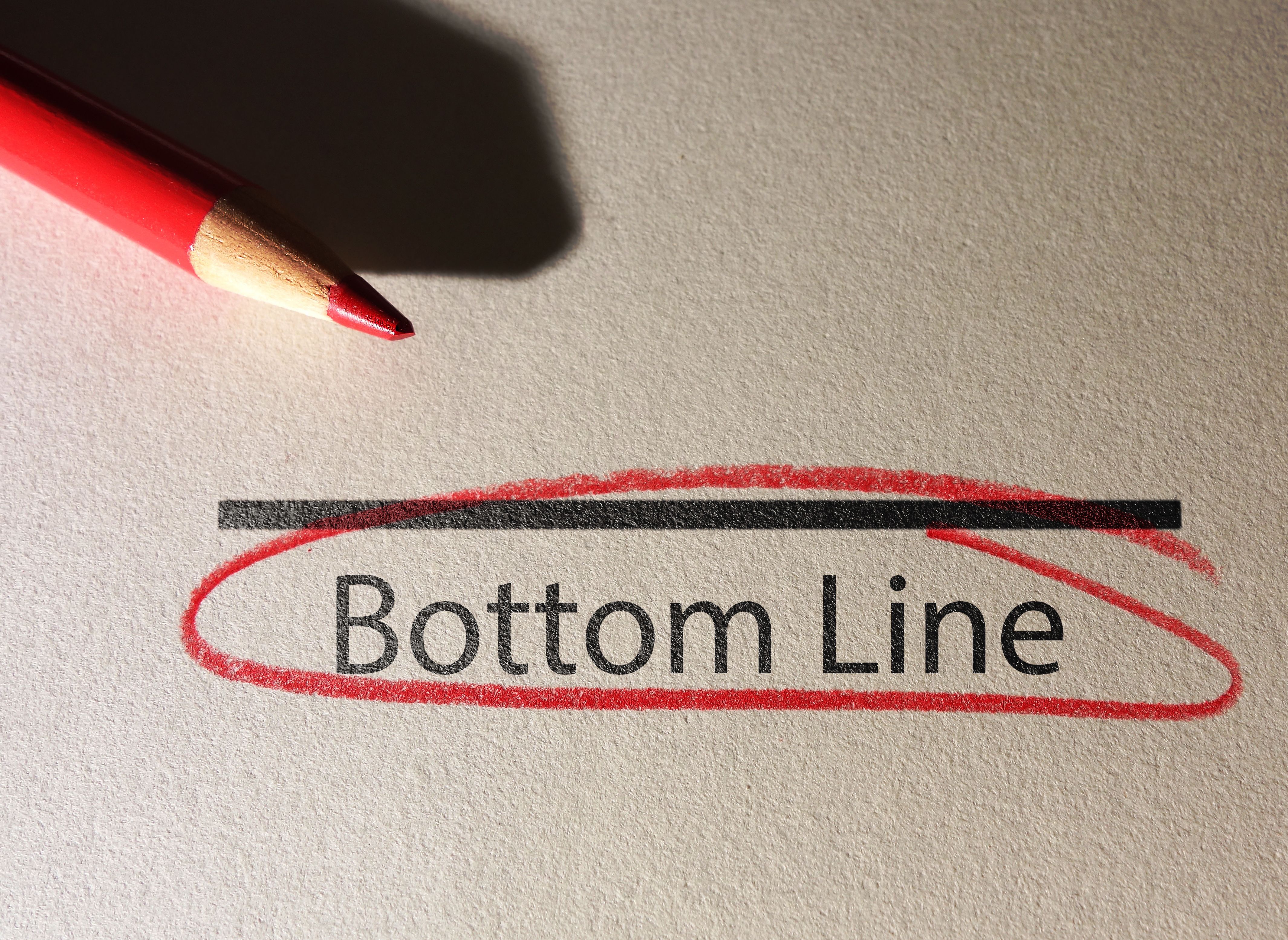 Bottom Line text circled in red pencil on textured paper Bottom Line text circled in red pencil on textured paper