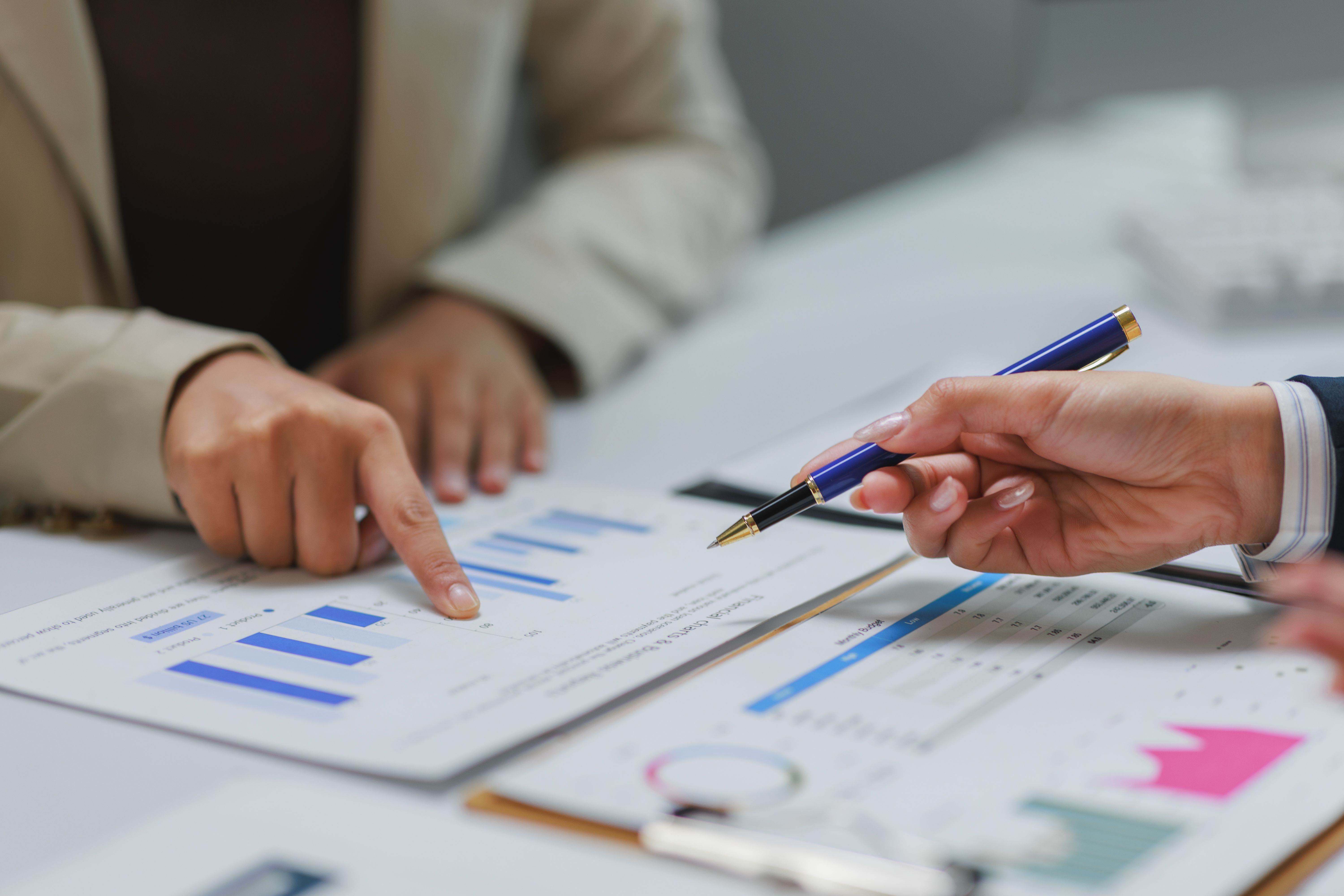 Businesswomen analyzing financial charts and data at office meeting