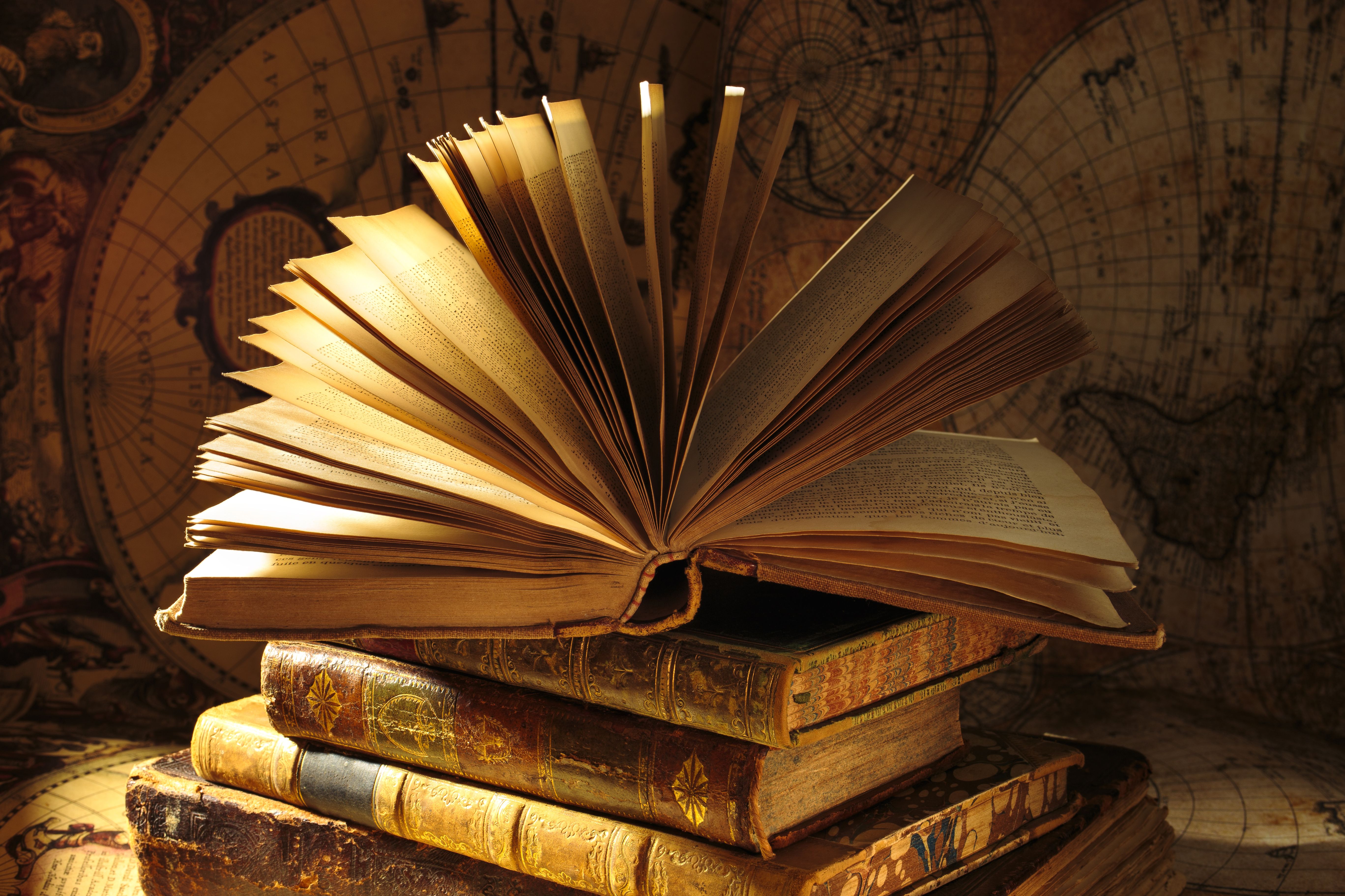 Old open book. Set of antique books on vintage map background