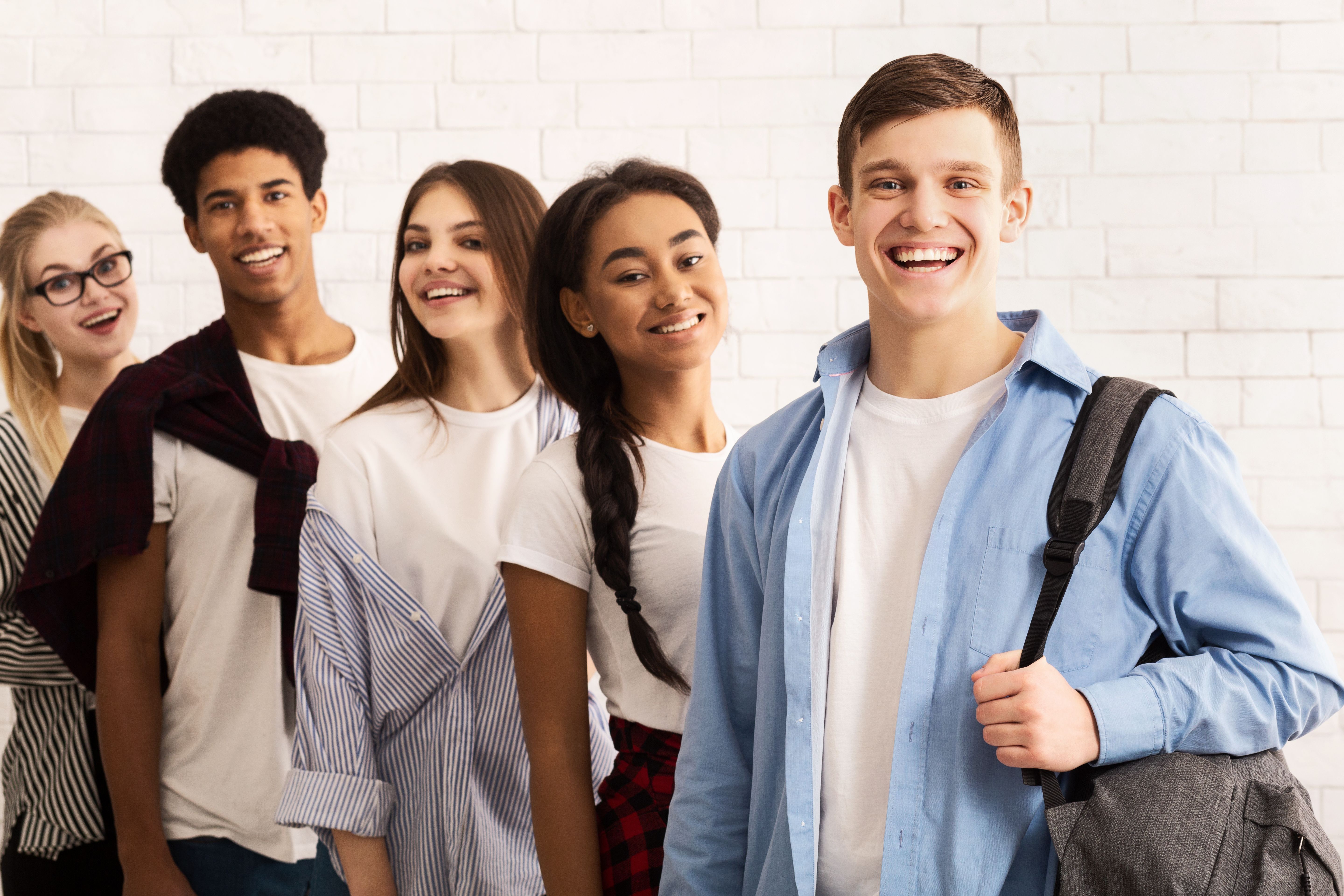 Group of Cheerful Friends Standing Together in a Modern Indoor Space During Daytime