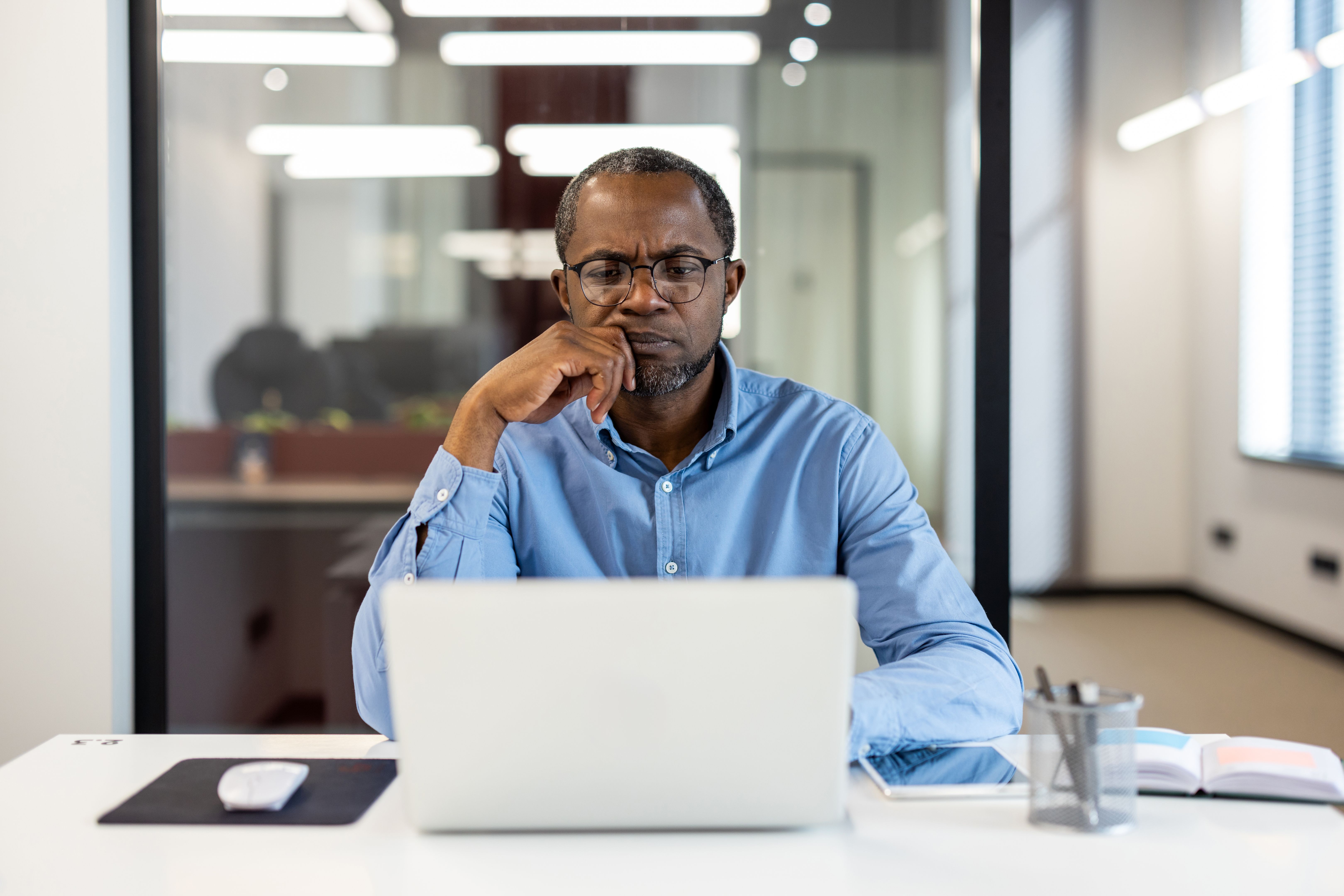 Focused businessman working on laptop in modern office