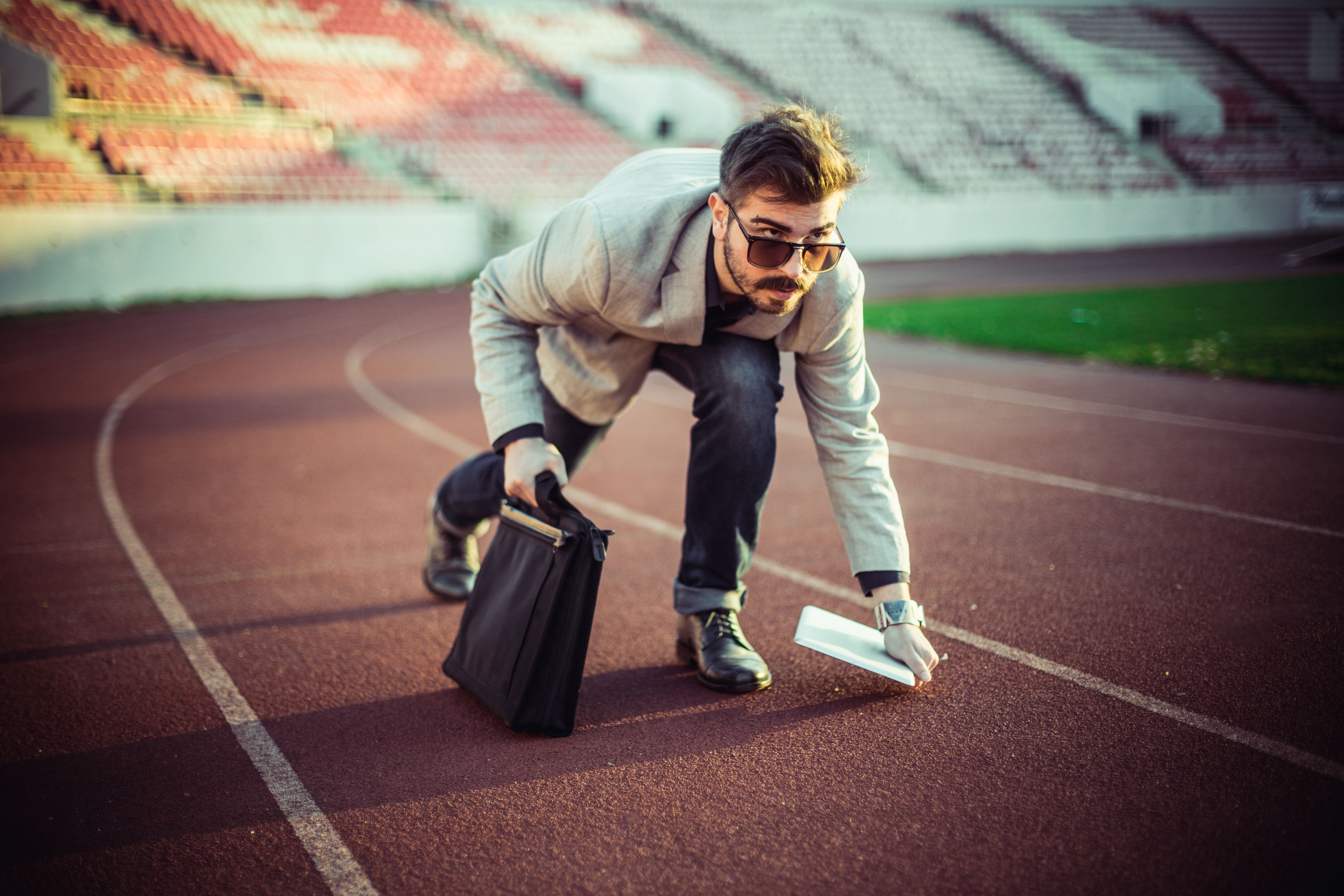 Young businessman with tablet preparing for race