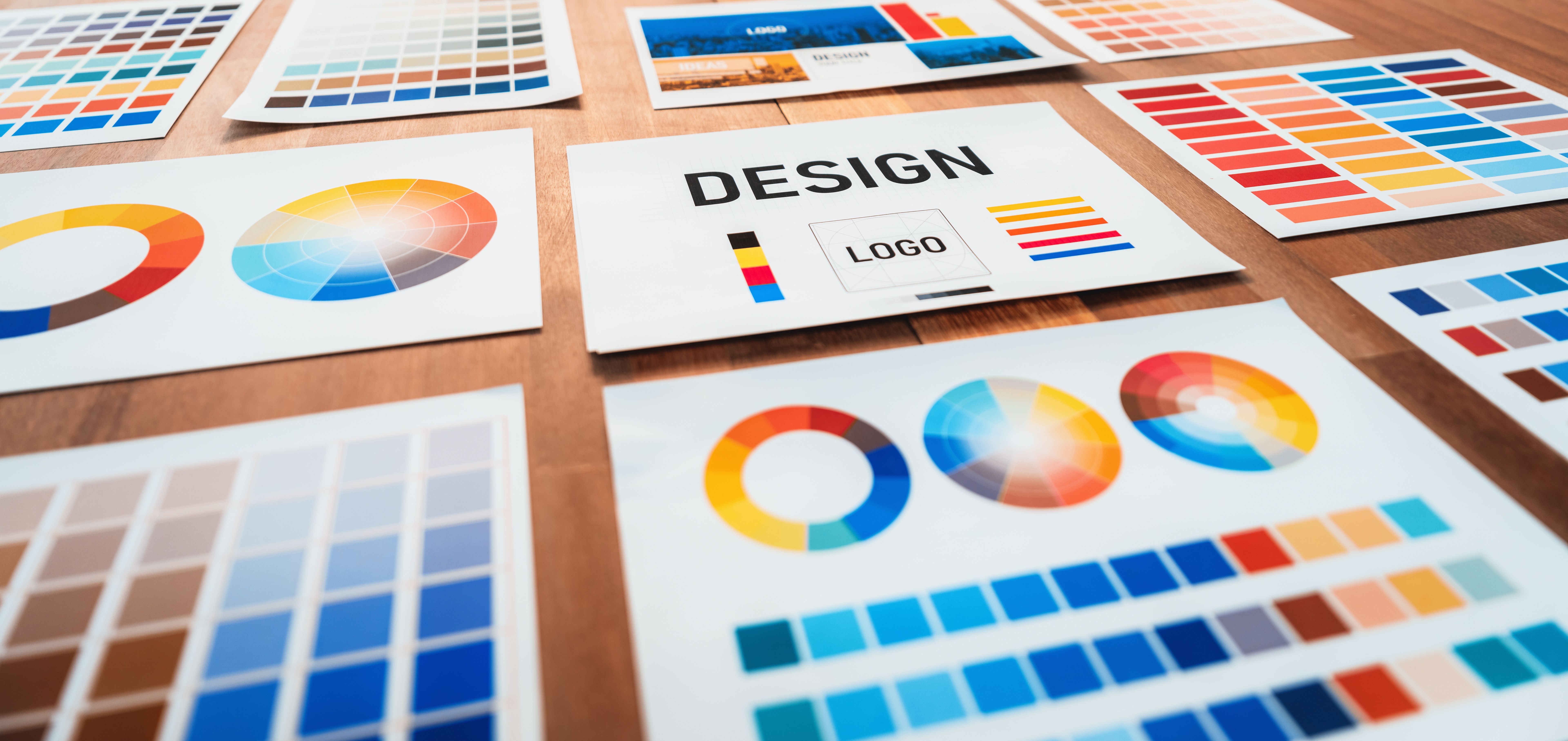 Various color palette idea papers arranged on workspace for designer. Scrutinize Various color palette idea papers arranged on workspace for designer. Scrutinize