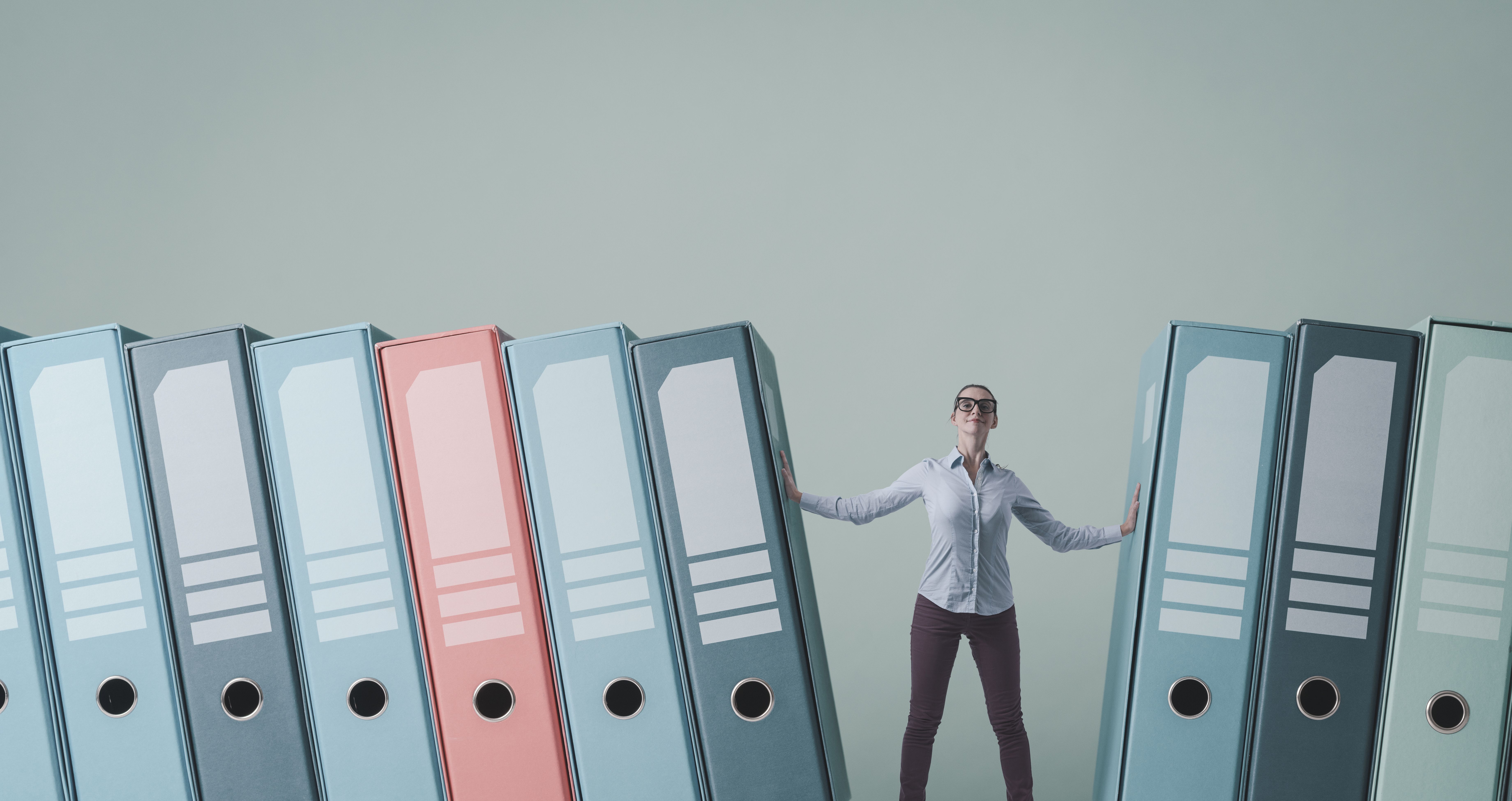 Businesswoman holding ring binders with tax forms Businesswoman holding ring binders with tax forms