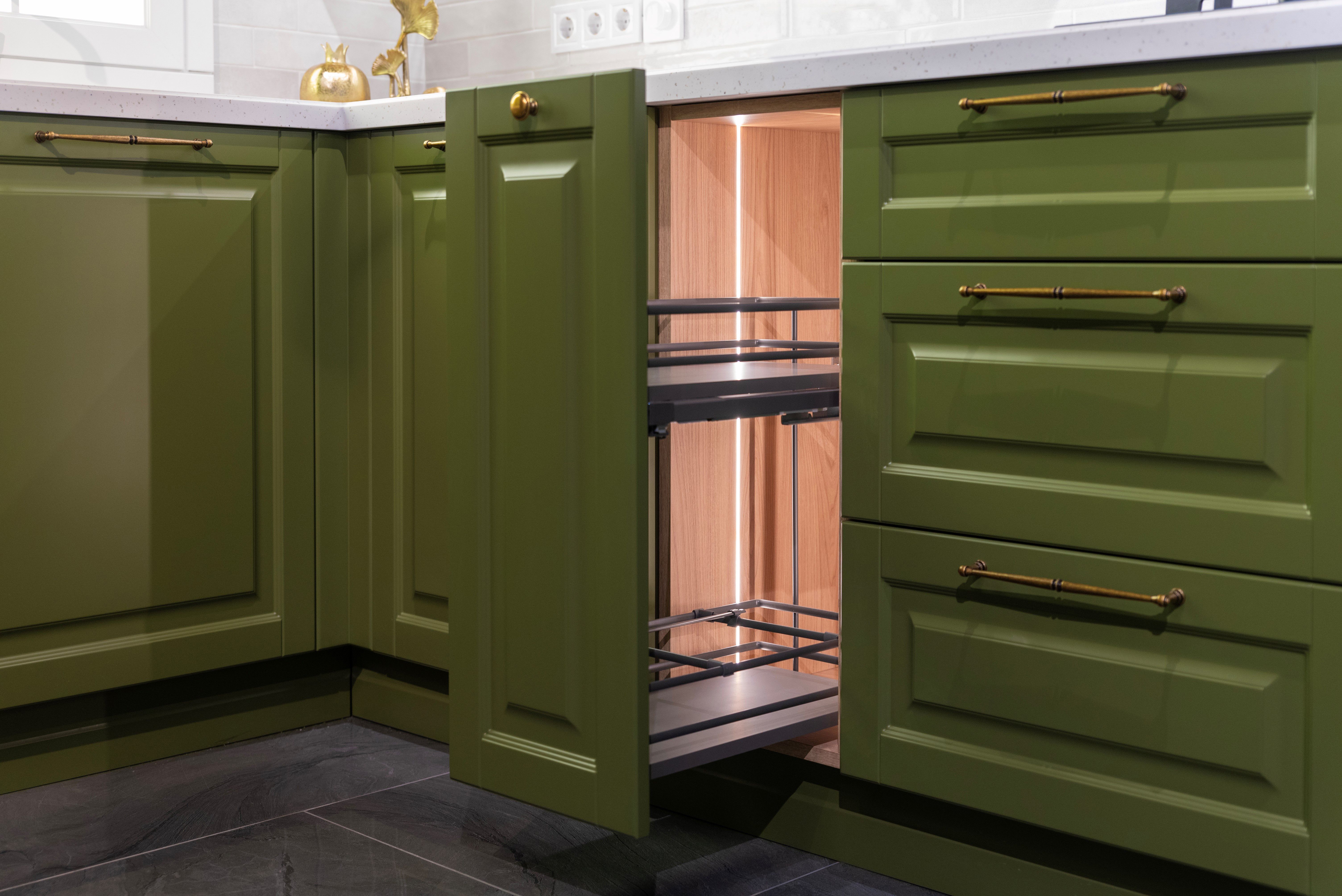 Open drawer in a green kitchen cabinet