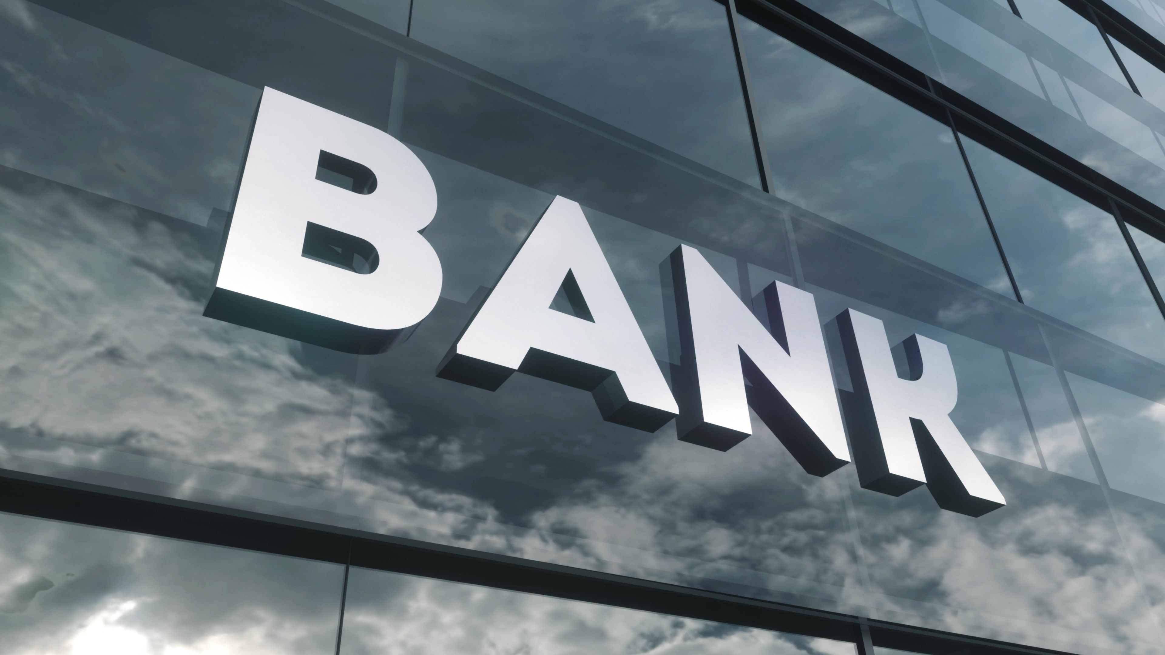 Bank sign on glass building. Mirrored sky and city on modern facade. Business and finance concept. 3d illustration