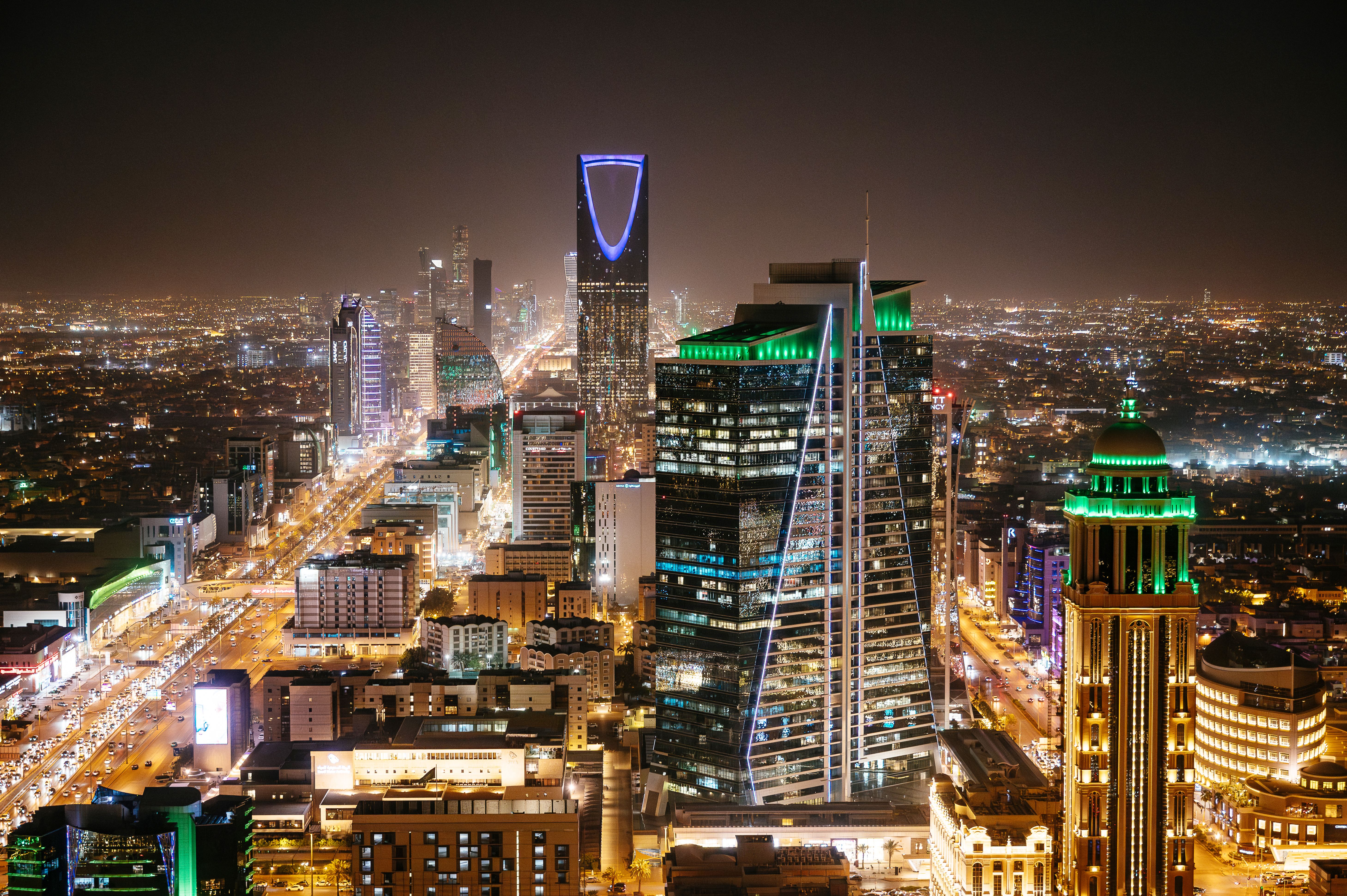 Aerial view of Riyadh at night with illuminated modern skyscrapers and busy streets under a clear dark sky, Al Olaya street