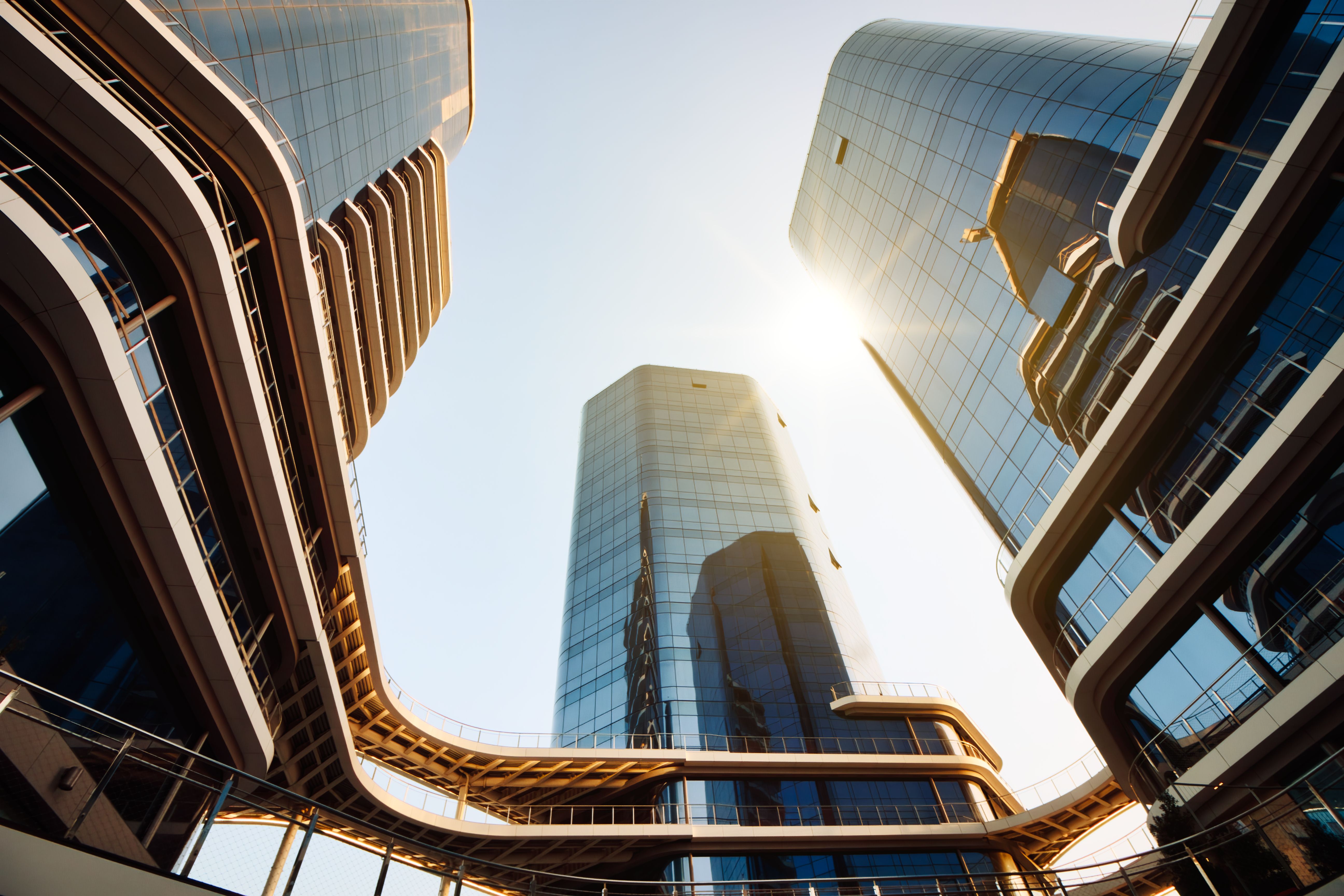 Cityscape view from below looking directly up at tall high-rise modern business buildings with glass facade